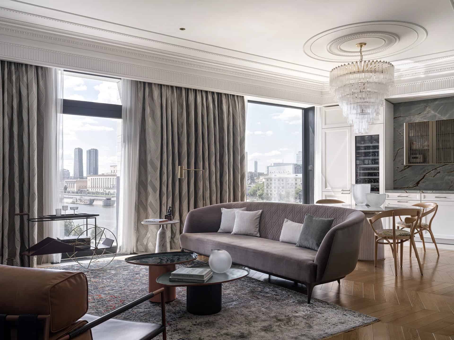 Apartment with a Parisian Mood for Collectors Open-Plan Overview by AABA Architects Open-plan living–dining view with chandelier and stone kitchen backdrop — AABA Architects, Moscow