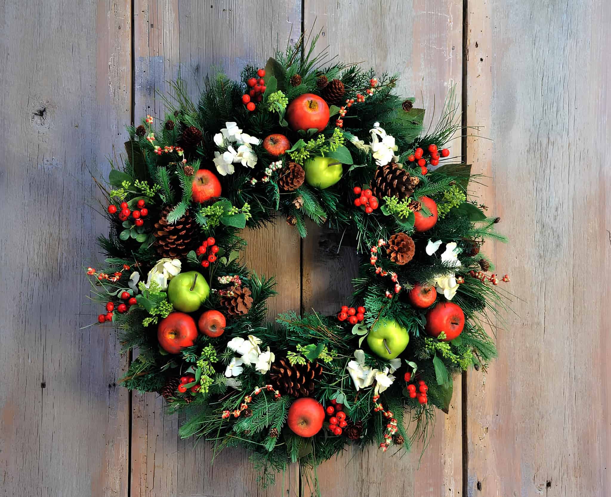 Christmas wreath with apples, pinecones, berries, and winter greenery