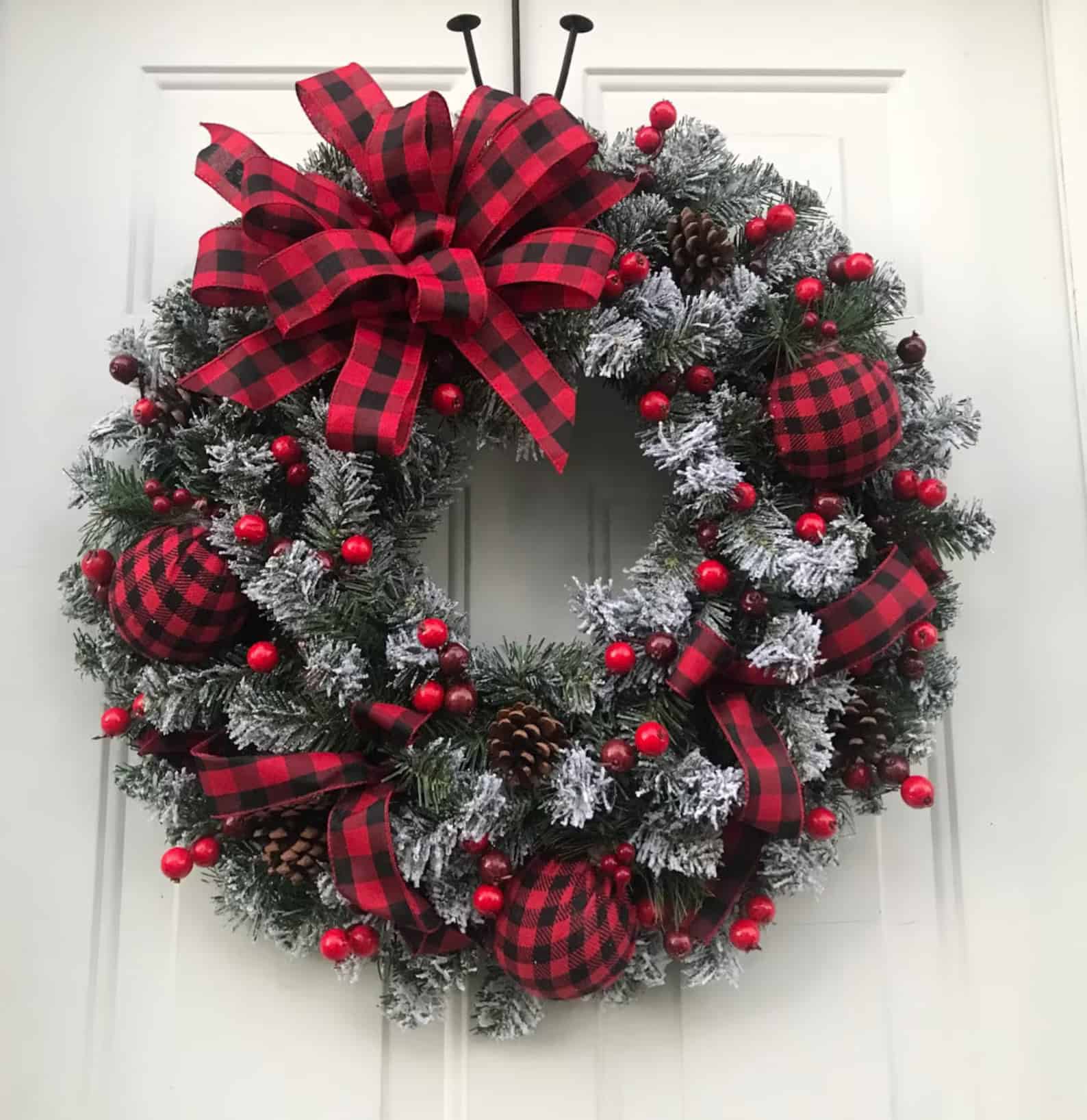 Buffalo plaid bow Christmas wreath with frosted greenery and red berries