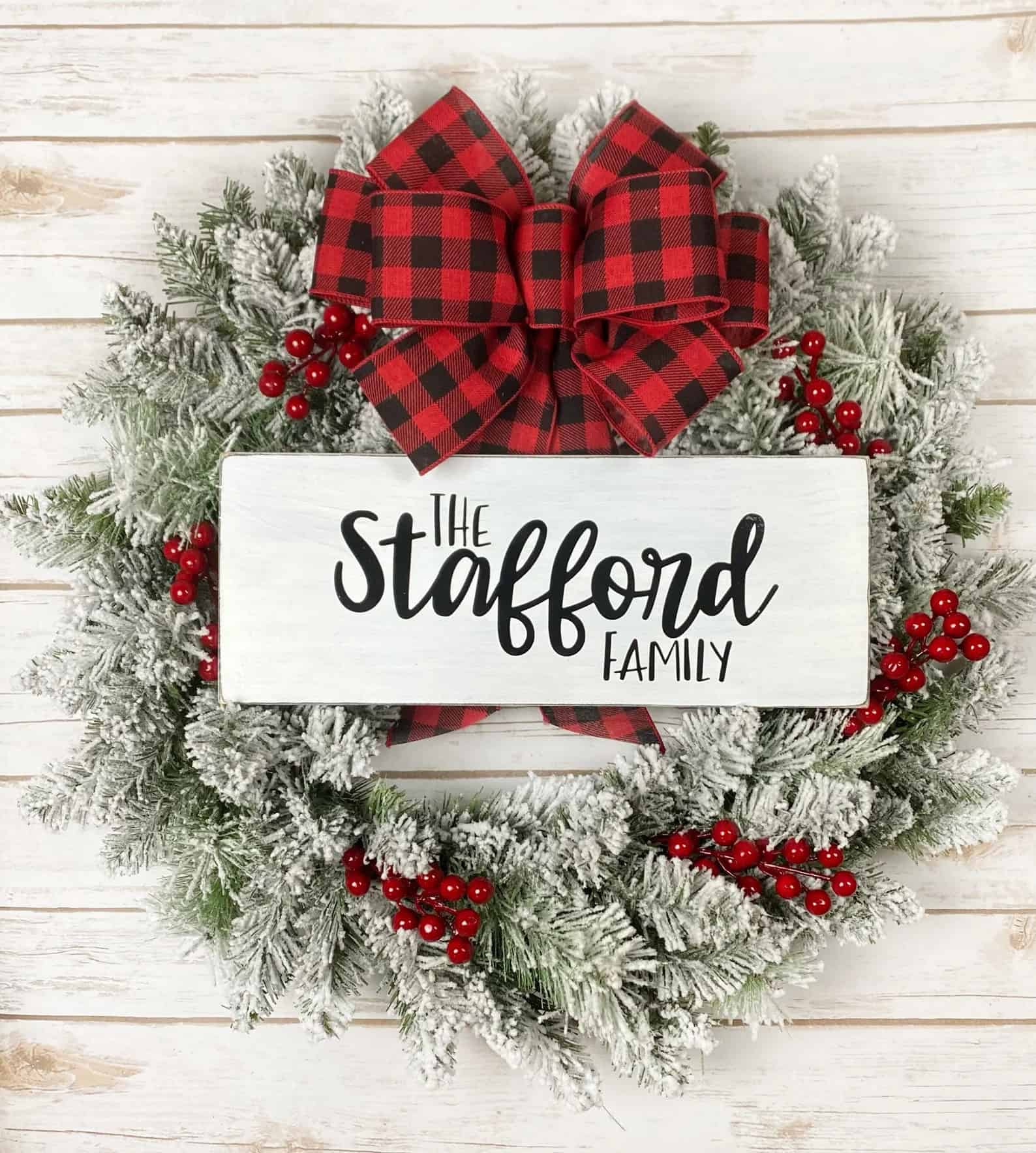 Flocked Christmas wreath with red berries, plaid bow and custom family sign