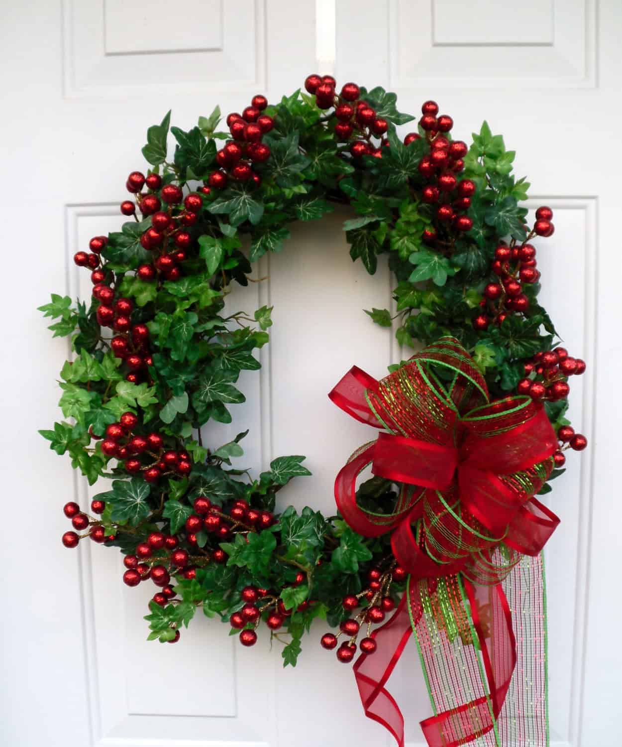 Ivy wreath packed with red berries and a festive red-green ribbon bow