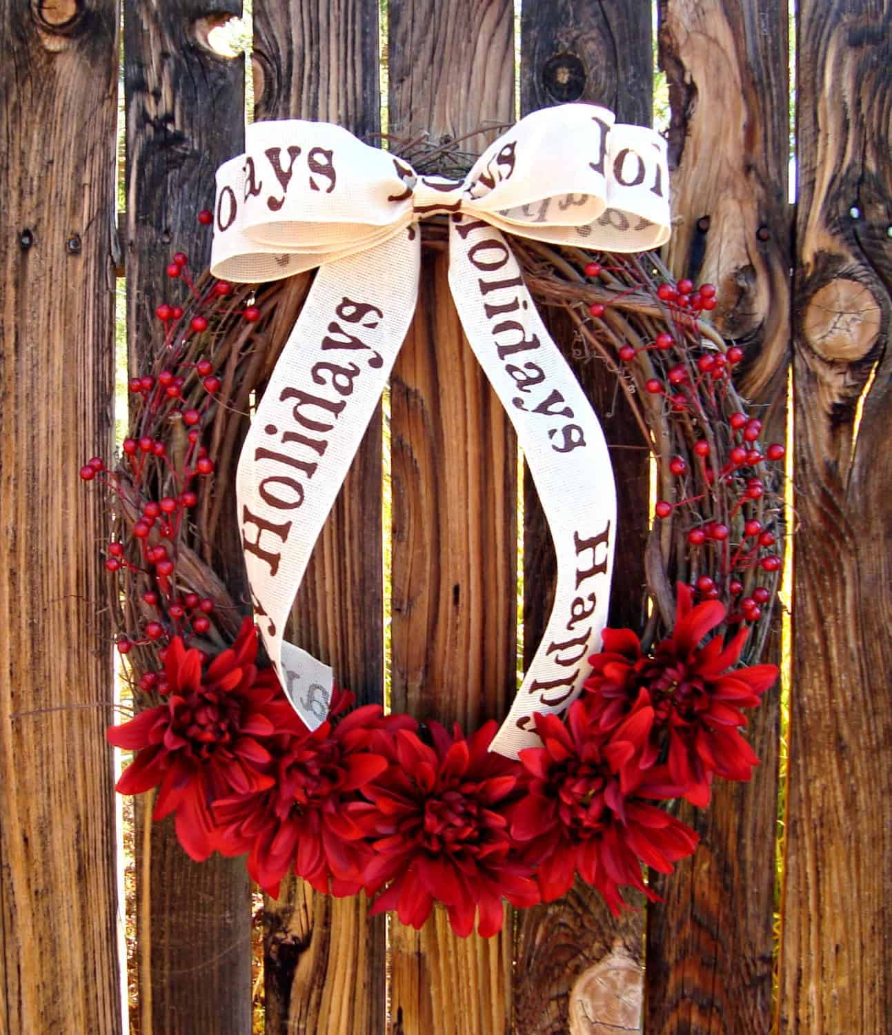 Rustic grapevine wreath with deep red dahlias and berries and Happy Holidays ribbon