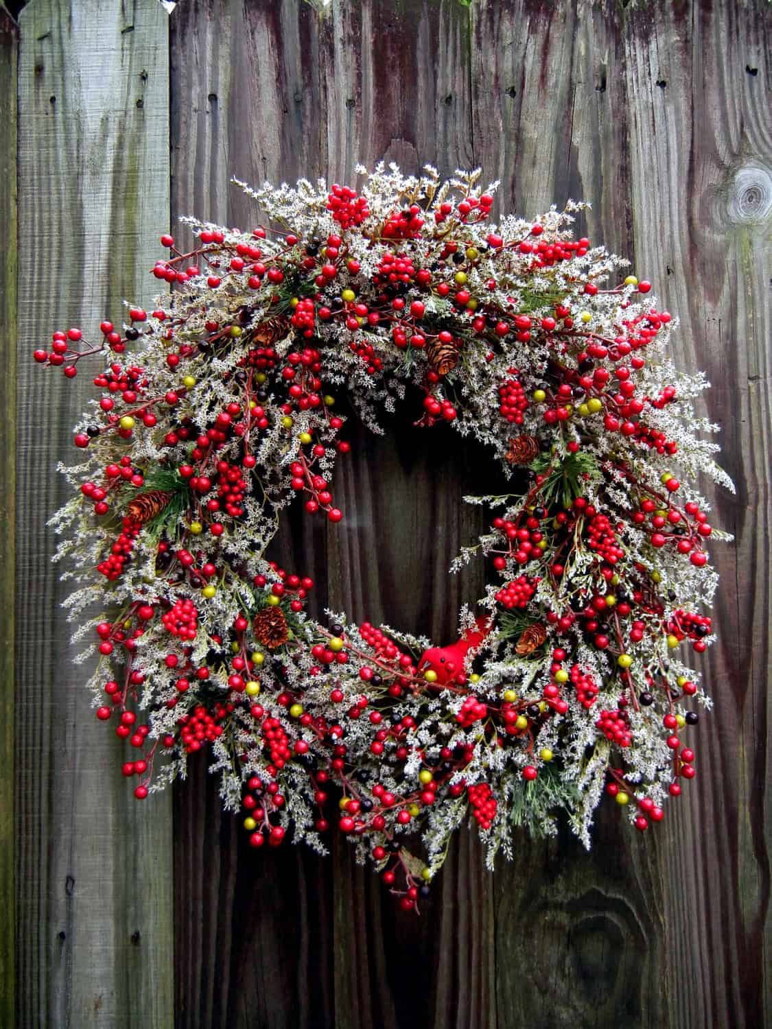 Frosted Christmas berry wreath with a red cardinal and snowy greenery