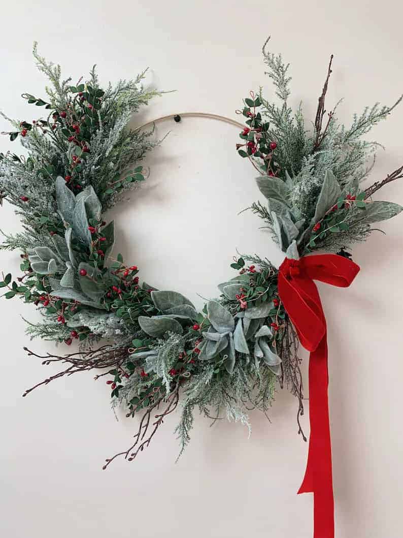 Elegant holiday wreath with red ribbon and winter foliage