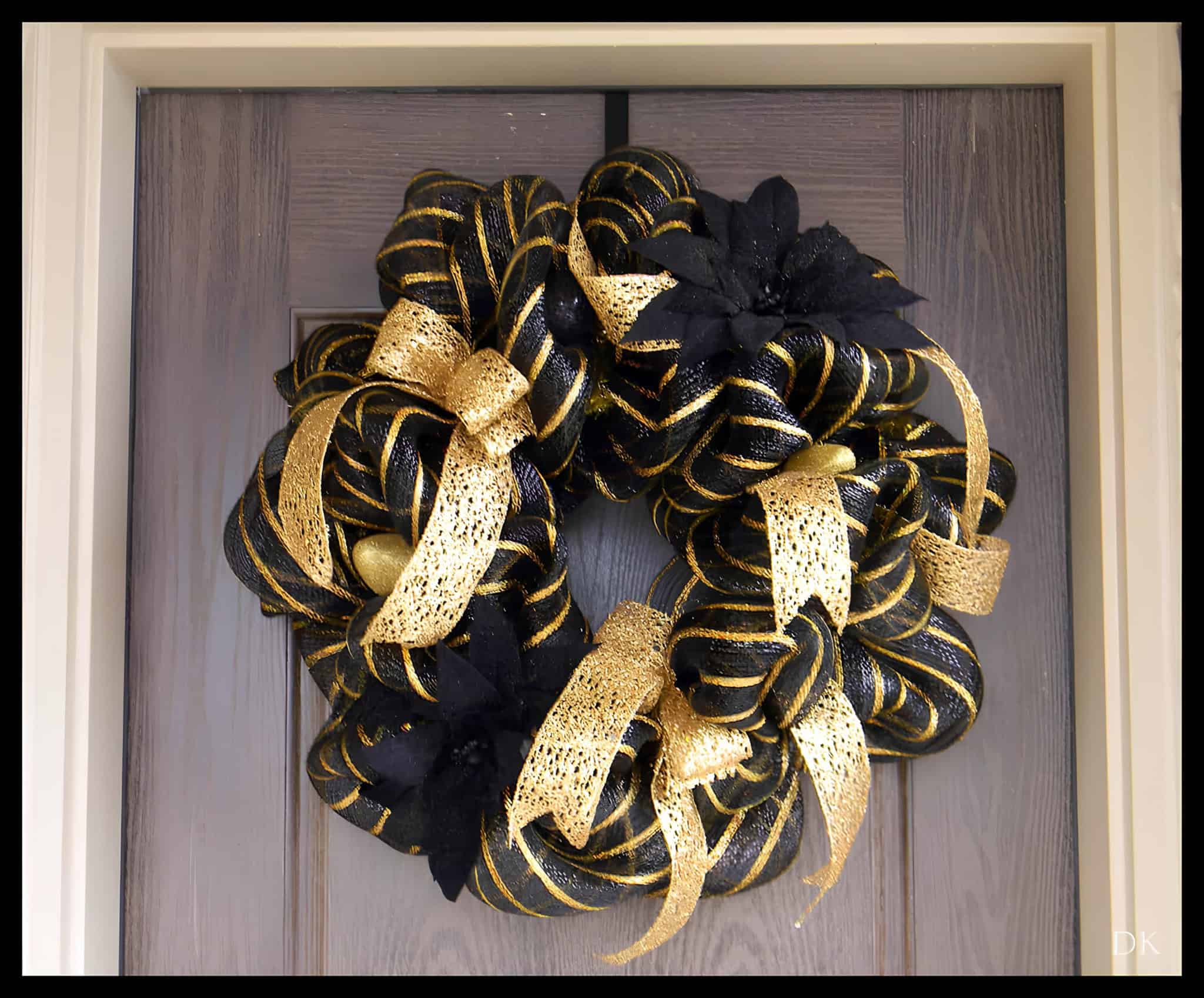 Elegant black and gold ribbon wreath with shimmering bows