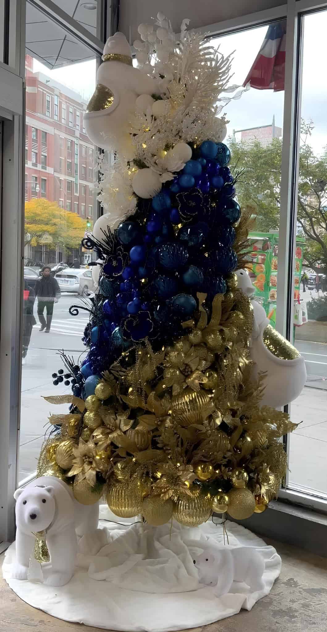 Blue and gold Christmas tree with polar bear decorations and glittering ornaments