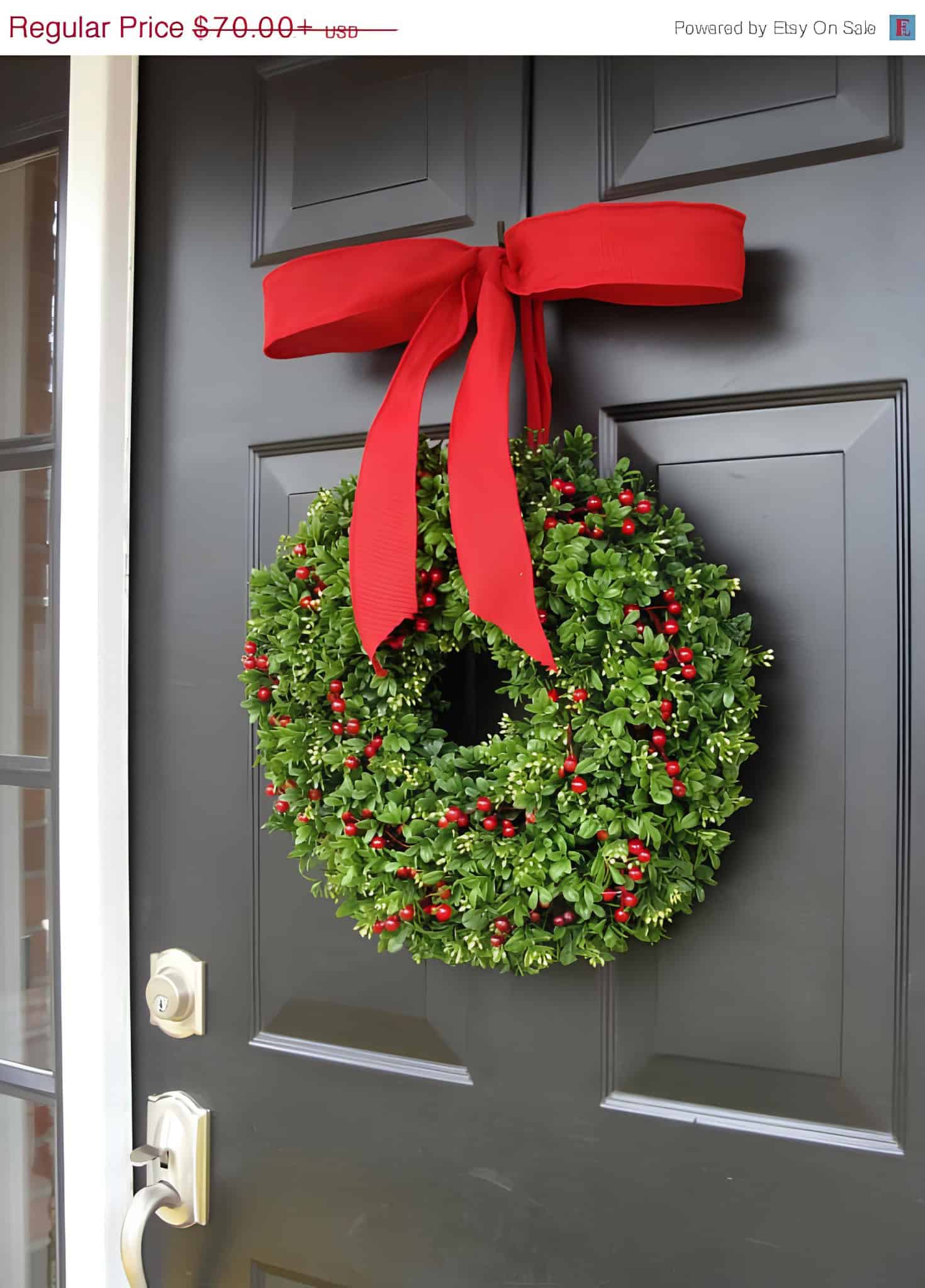 Lush boxwood wreath with red berries and a large red bow