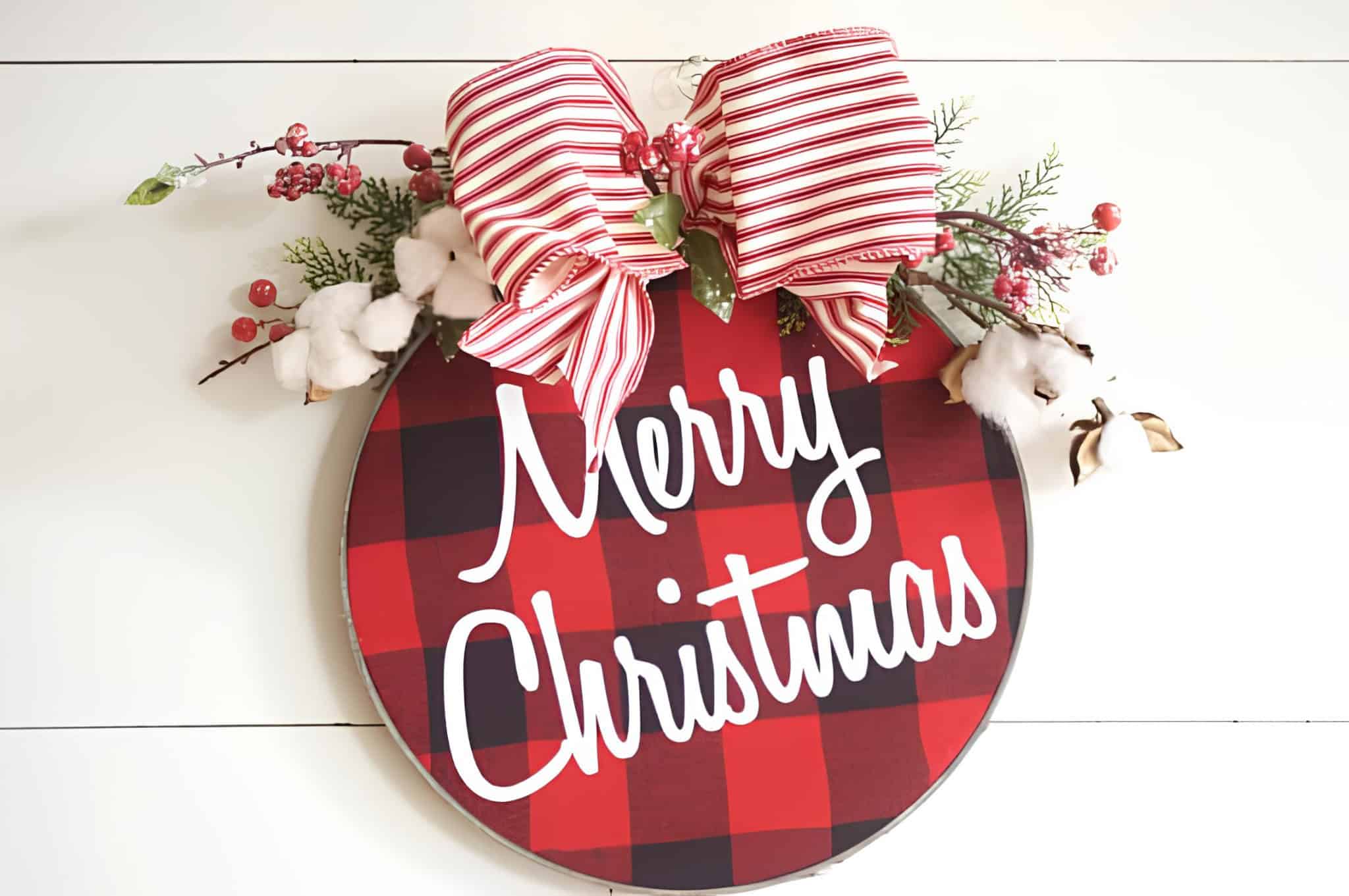 Buffalo plaid Merry Christmas sign with red-and-white striped bow, cotton and berries