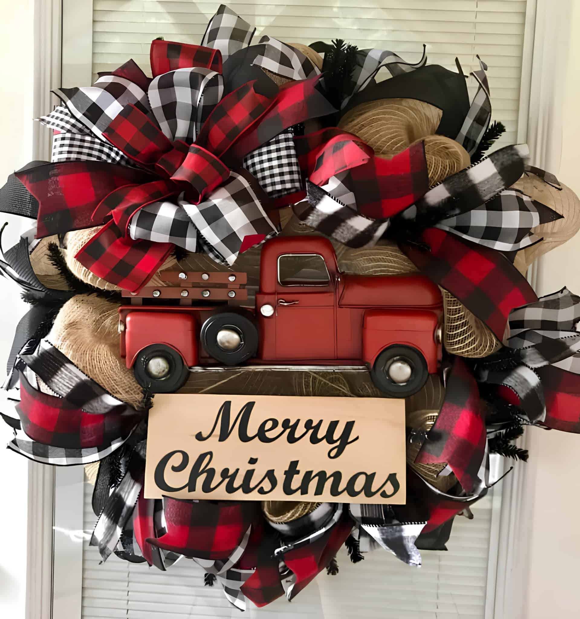 Burlap Christmas wreath with buffalo plaid bows and a vintage red truck Merry Christmas sign