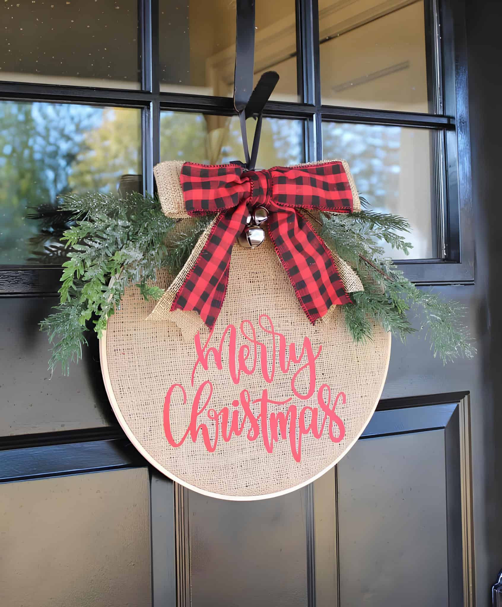 Burlap Merry Christmas door hanger with buffalo plaid bow, greenery and jingle bells