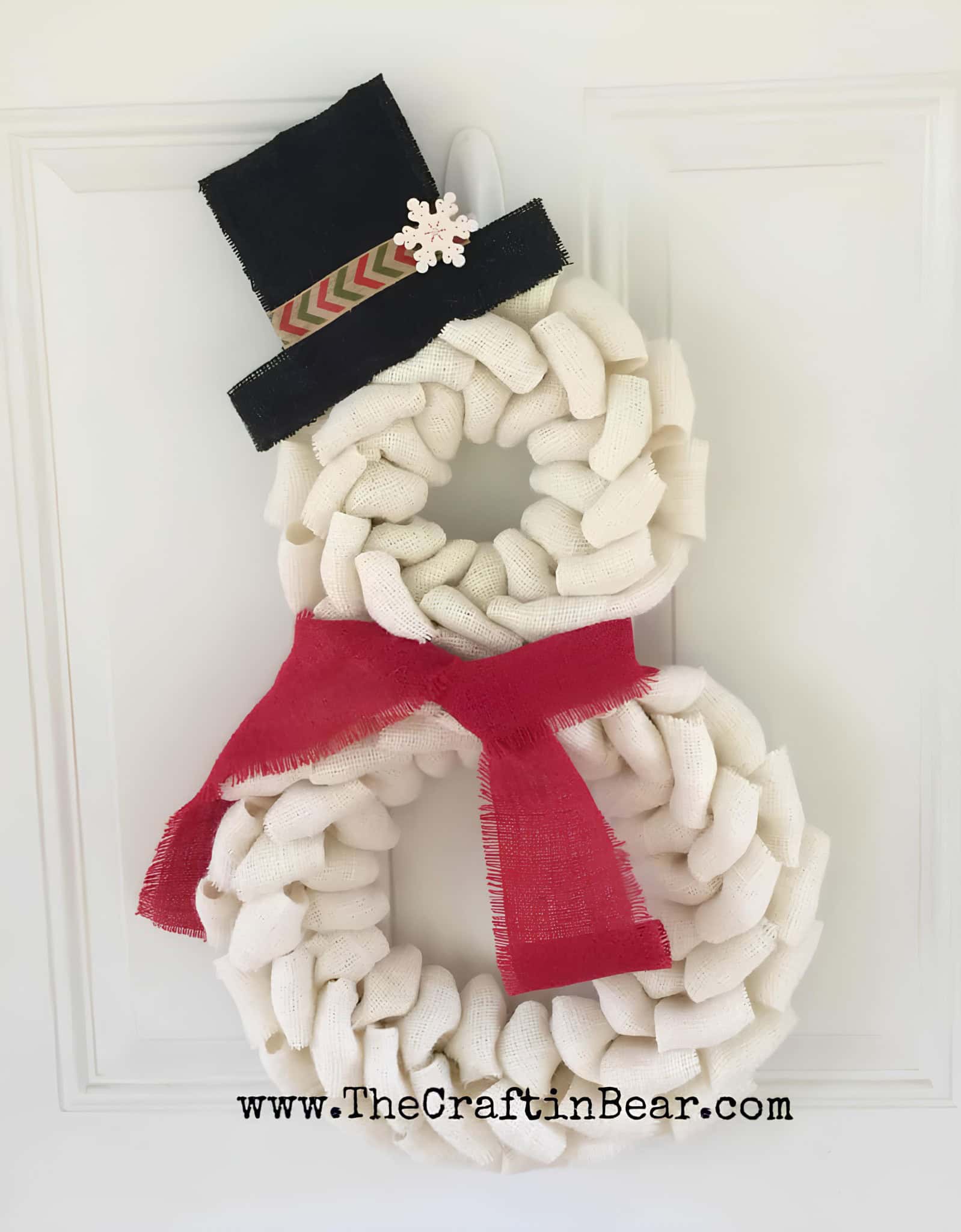 Snowman wreath made from white burlap with a black top hat and red scarf