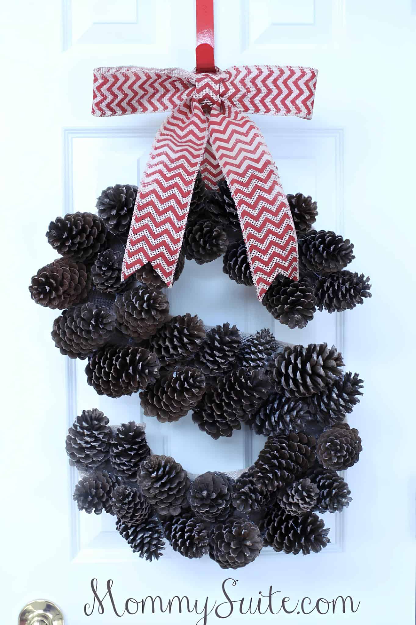 Evergreen wreath with pinecones, red berries and a cardinal ribbon bow