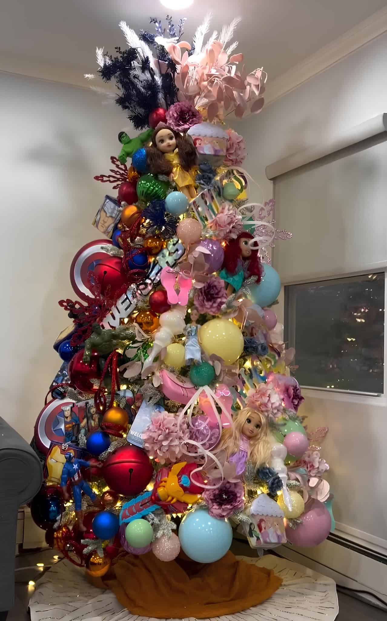 Playful Christmas tree with Barbie dolls, superheroes, pastel ornaments, and ribbons