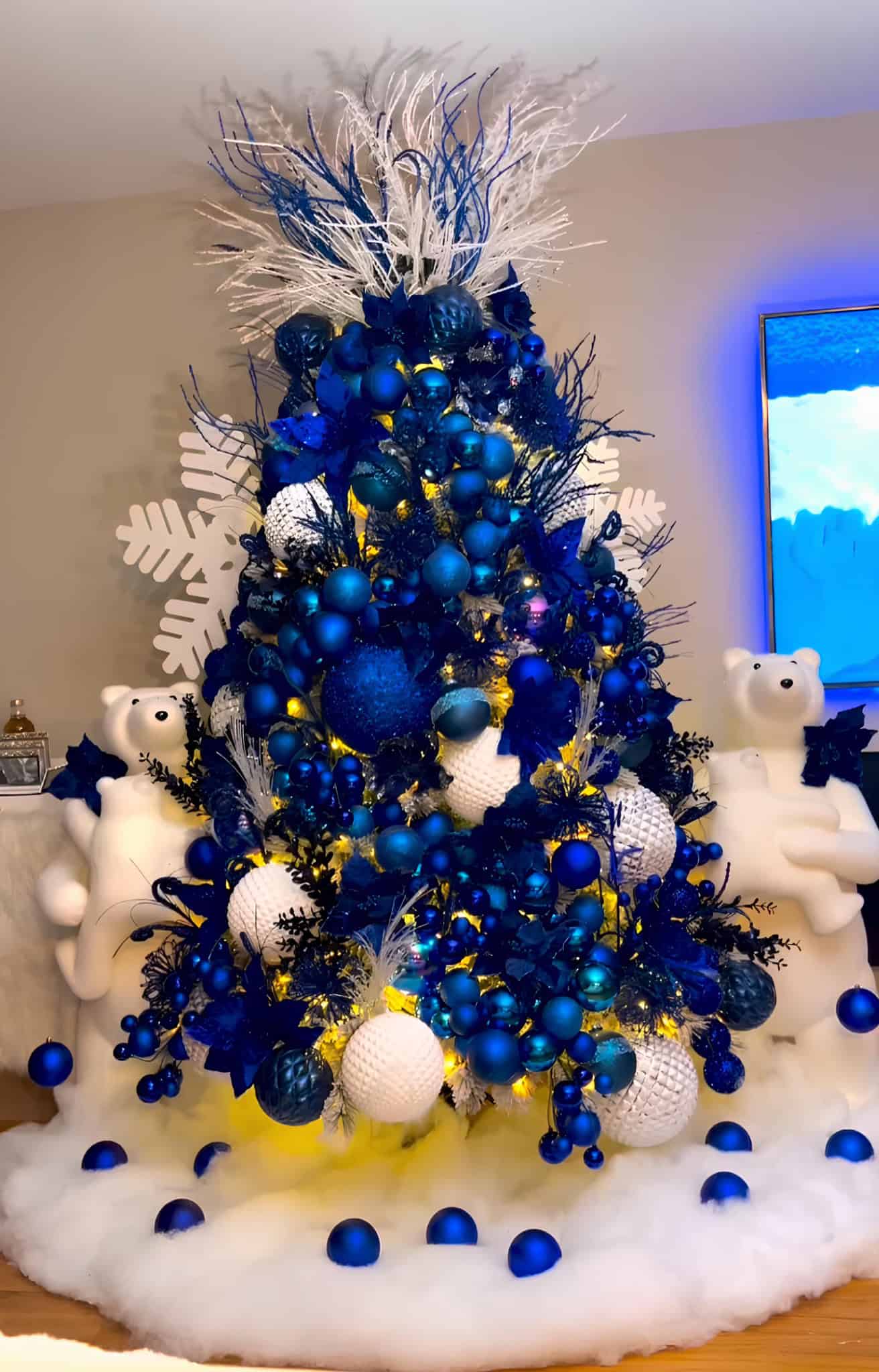 Blue and white winter Christmas tree with polar bear accents and snow effect