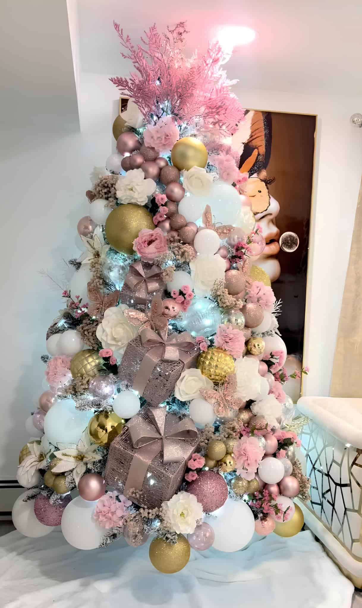 Blush pink and gold glam Christmas tree with gift boxes, white florals, and glitter ornaments