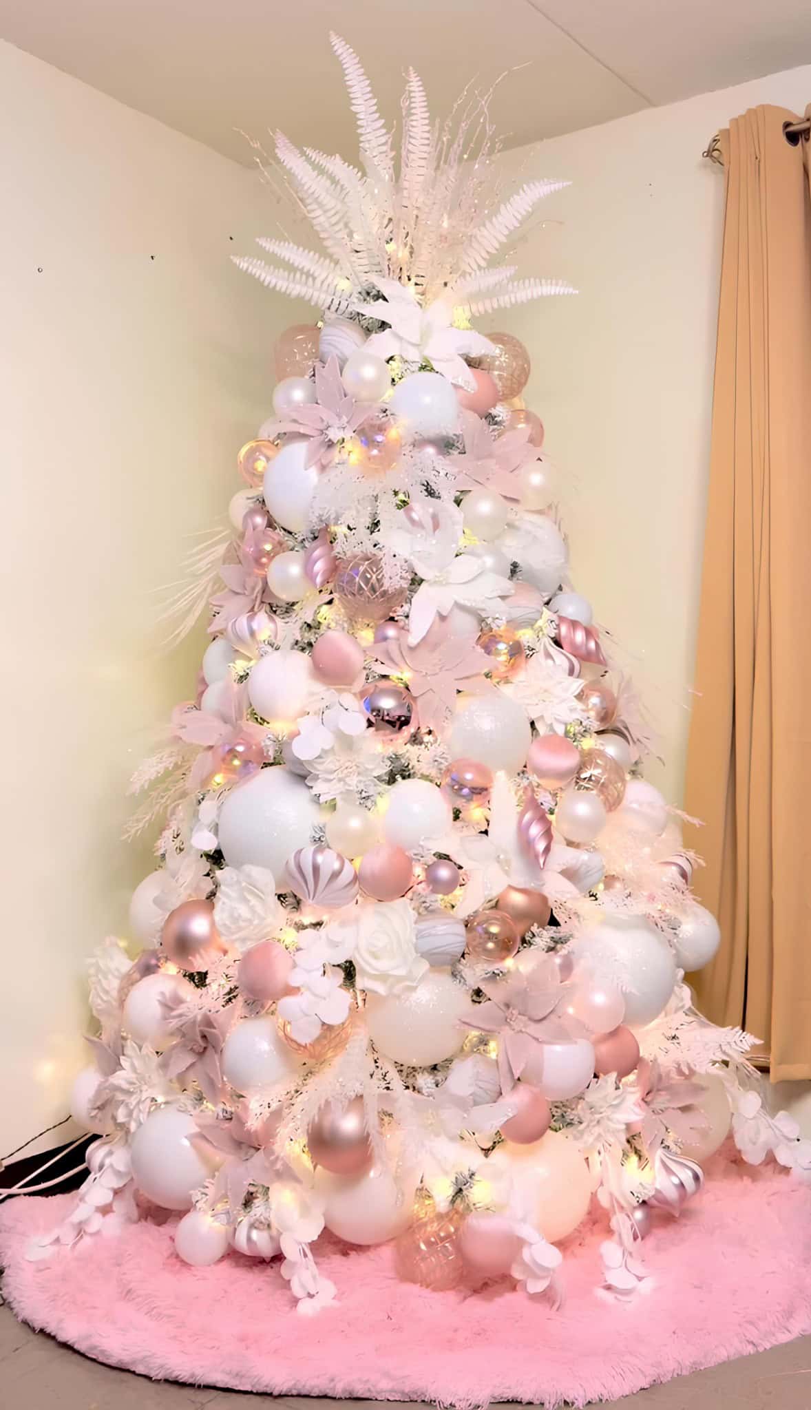 Soft blush pink and white Christmas tree with pastel ornaments and feathers