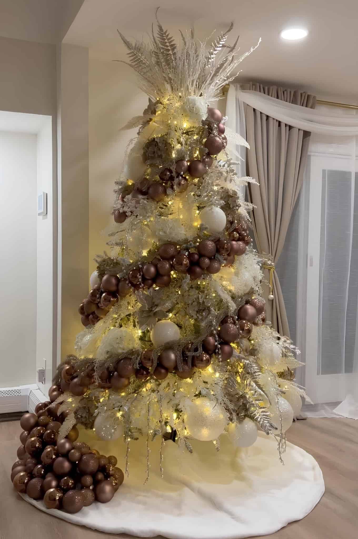 Warm copper and gold Christmas tree with cascading garlands and frosted branches
