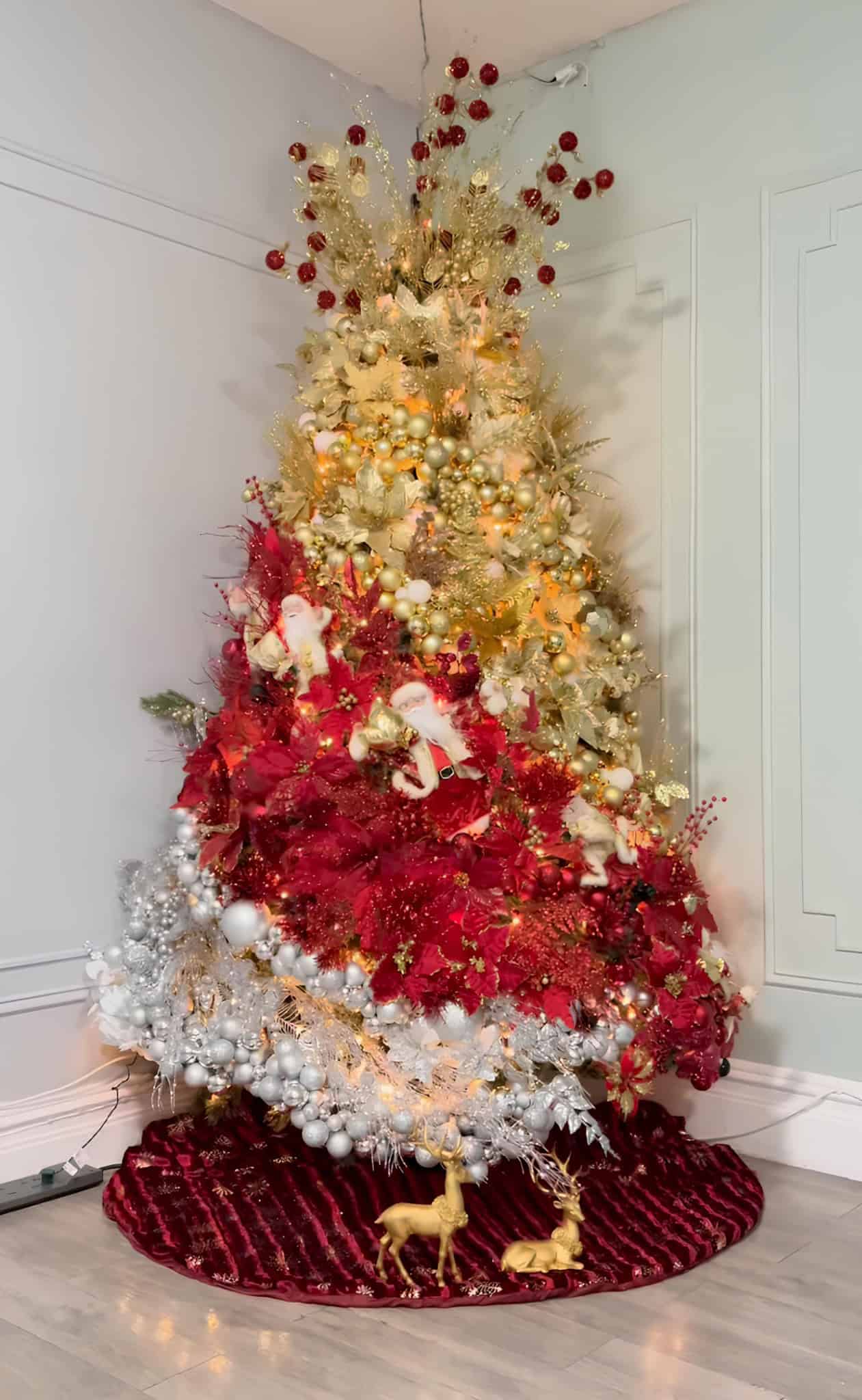 Christmas tree in gold, red, and silver with layered cascades of poinsettias and ornaments