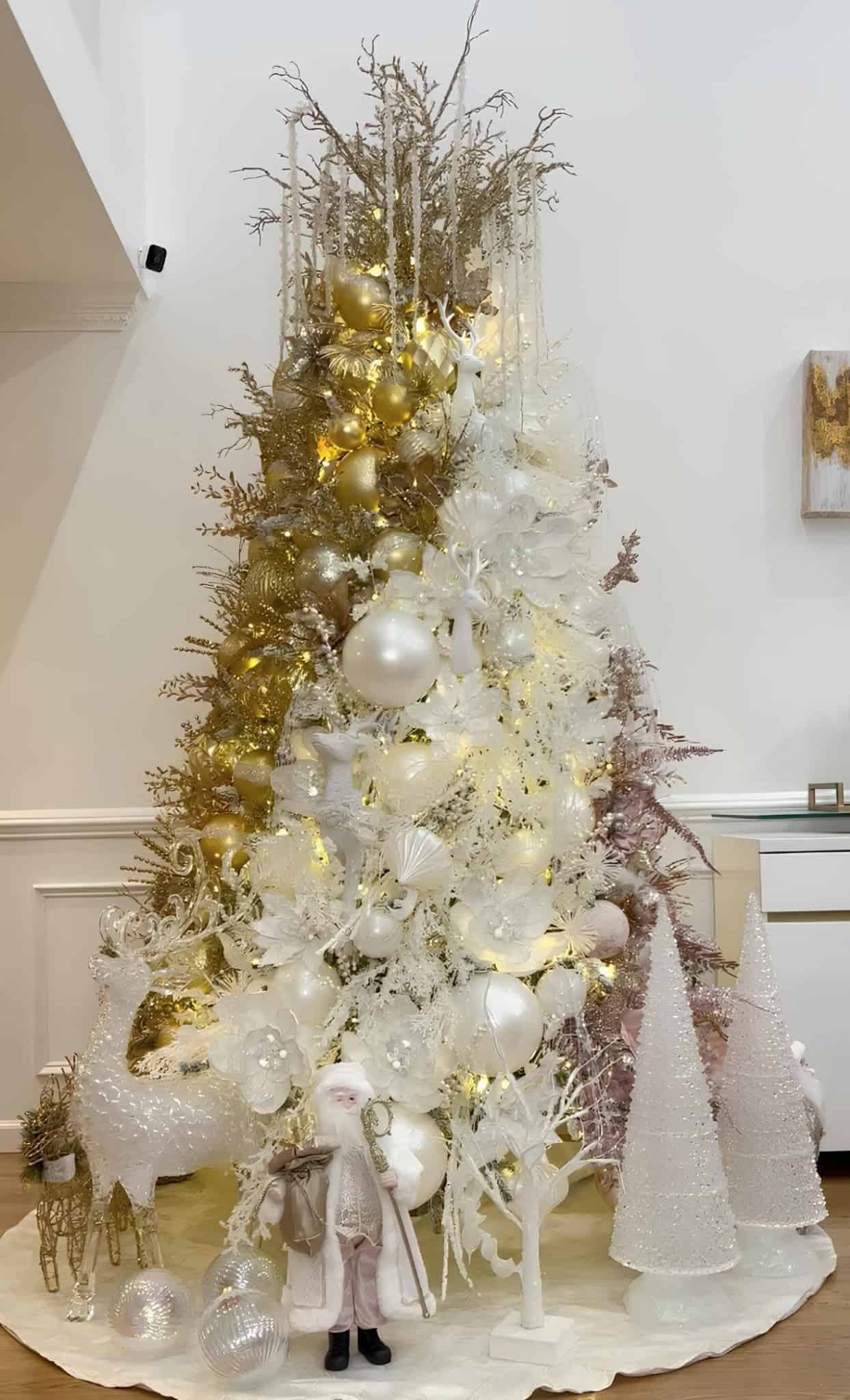 Gold and white Christmas tree with deer ornaments, glass accents, and glitter details