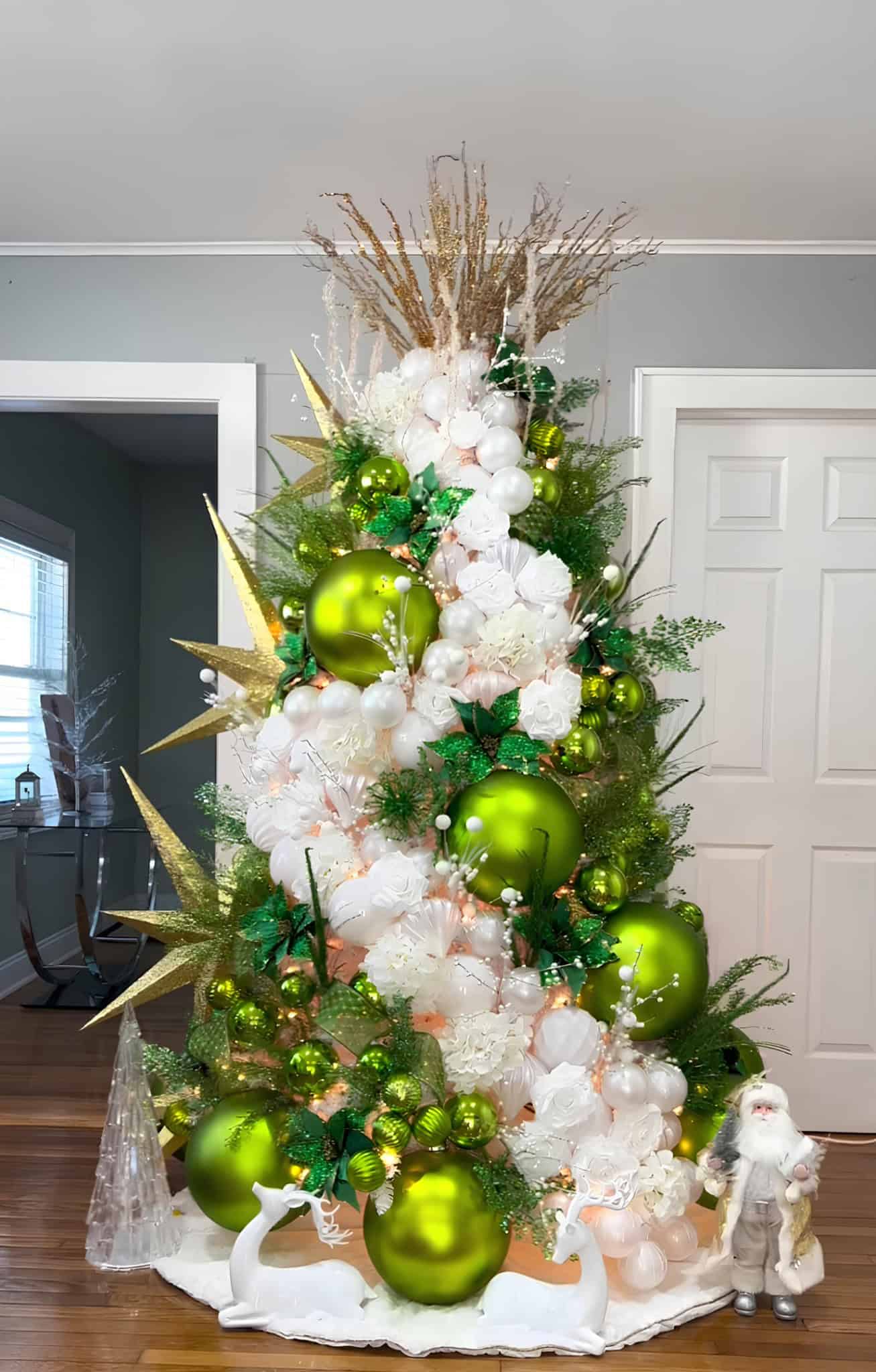 Christmas tree in lime green, white florals, and gold starbursts with deer décor