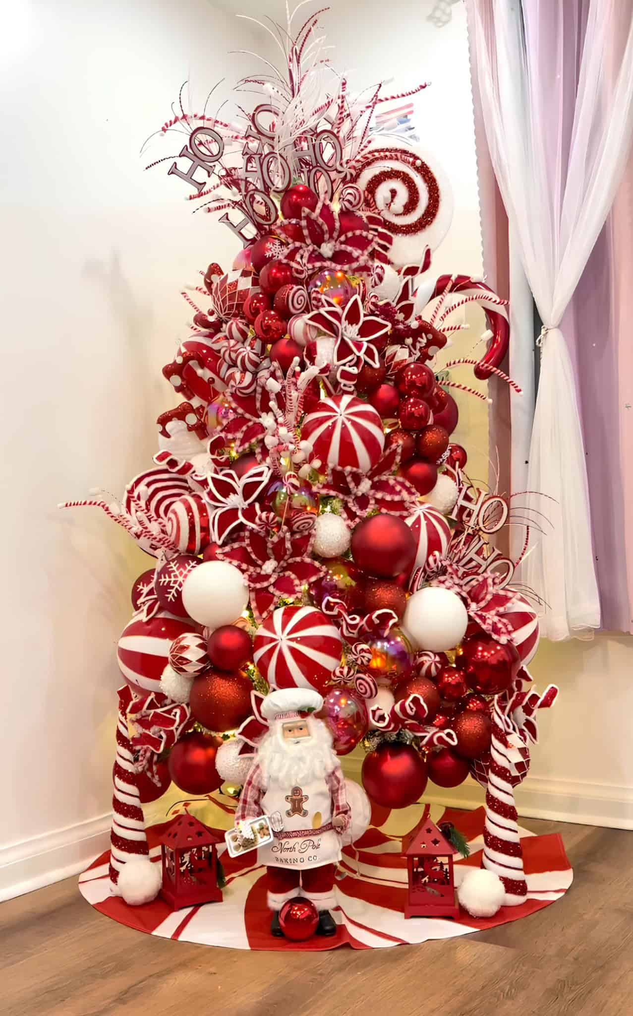 Red and white peppermint candy Christmas tree with lollipops, swirls, and North Pole bakery Santa