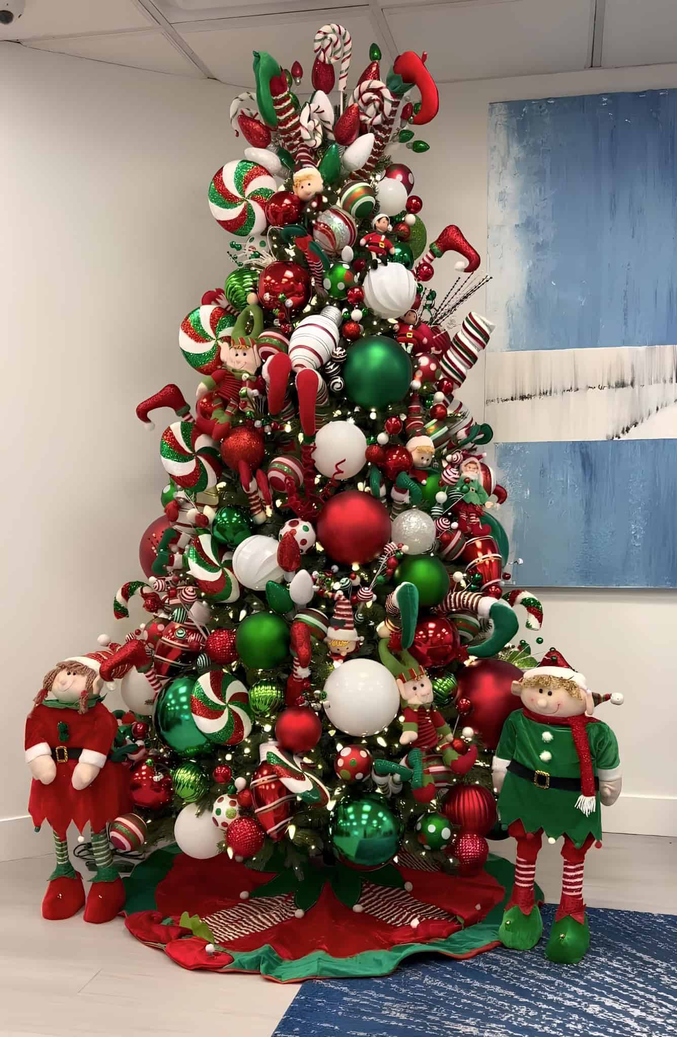 Red, green, and white peppermint candy Christmas tree with elves and oversized sweets