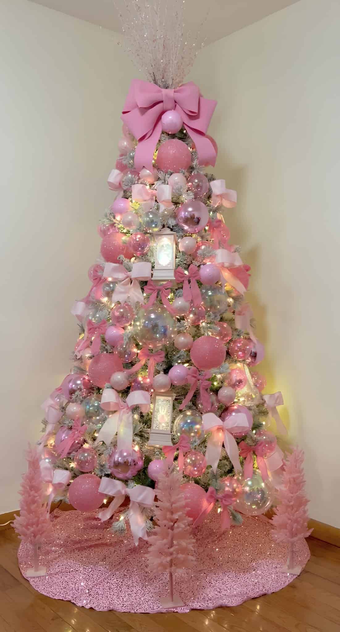 Soft pink Christmas tree with oversized bows, pastel ornaments, and iridescent globes