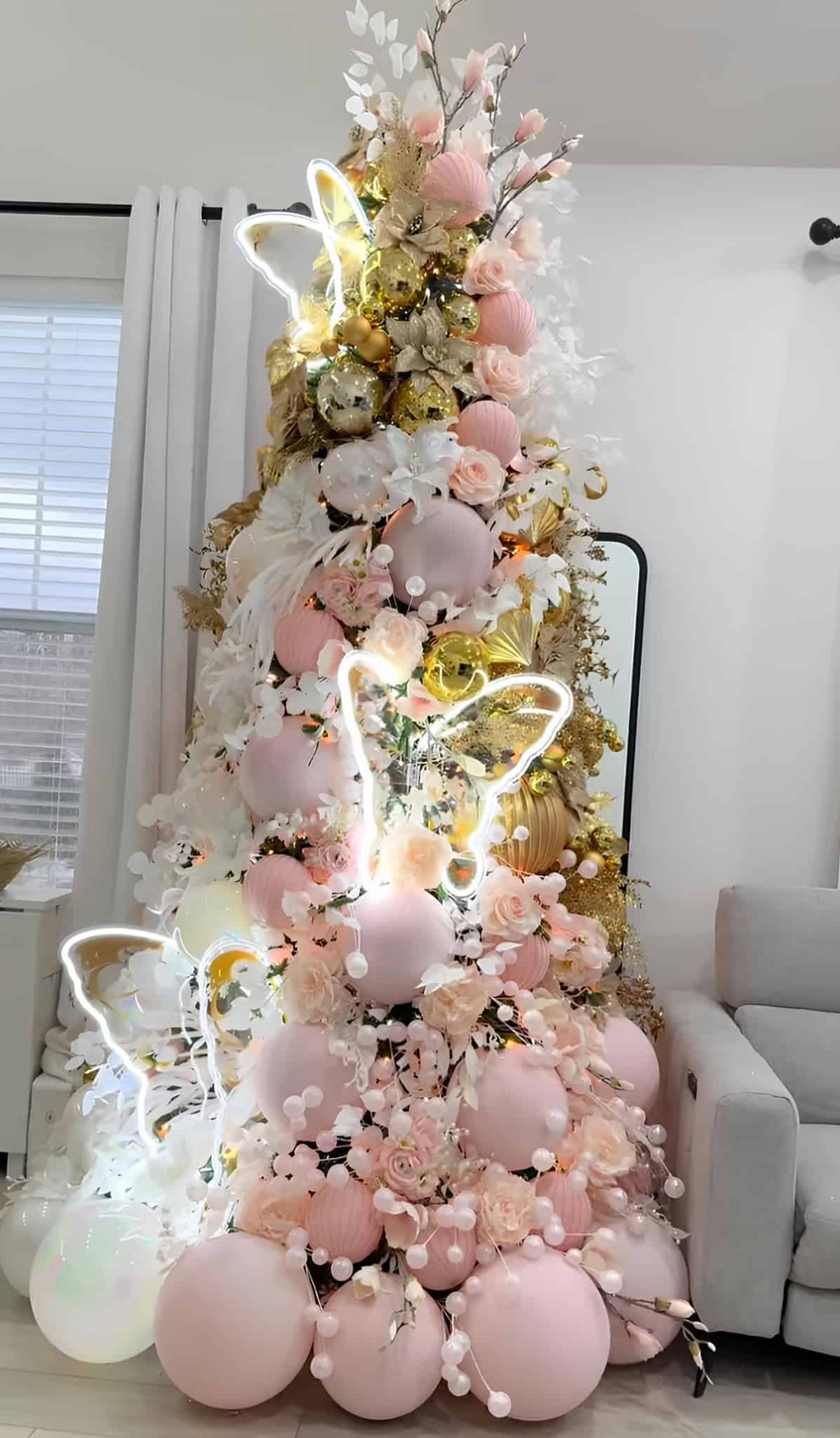 Pink and gold Christmas tree with neon butterfly lights and oversized ornaments