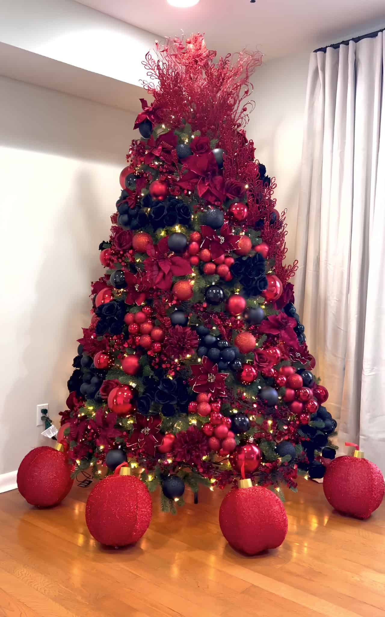 Bold red and black Christmas tree with poinsettias and deep ornaments