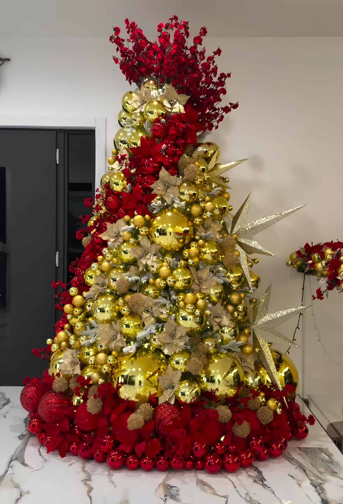 Glam red and gold Christmas tree with starburst sprays and bold poinsettias