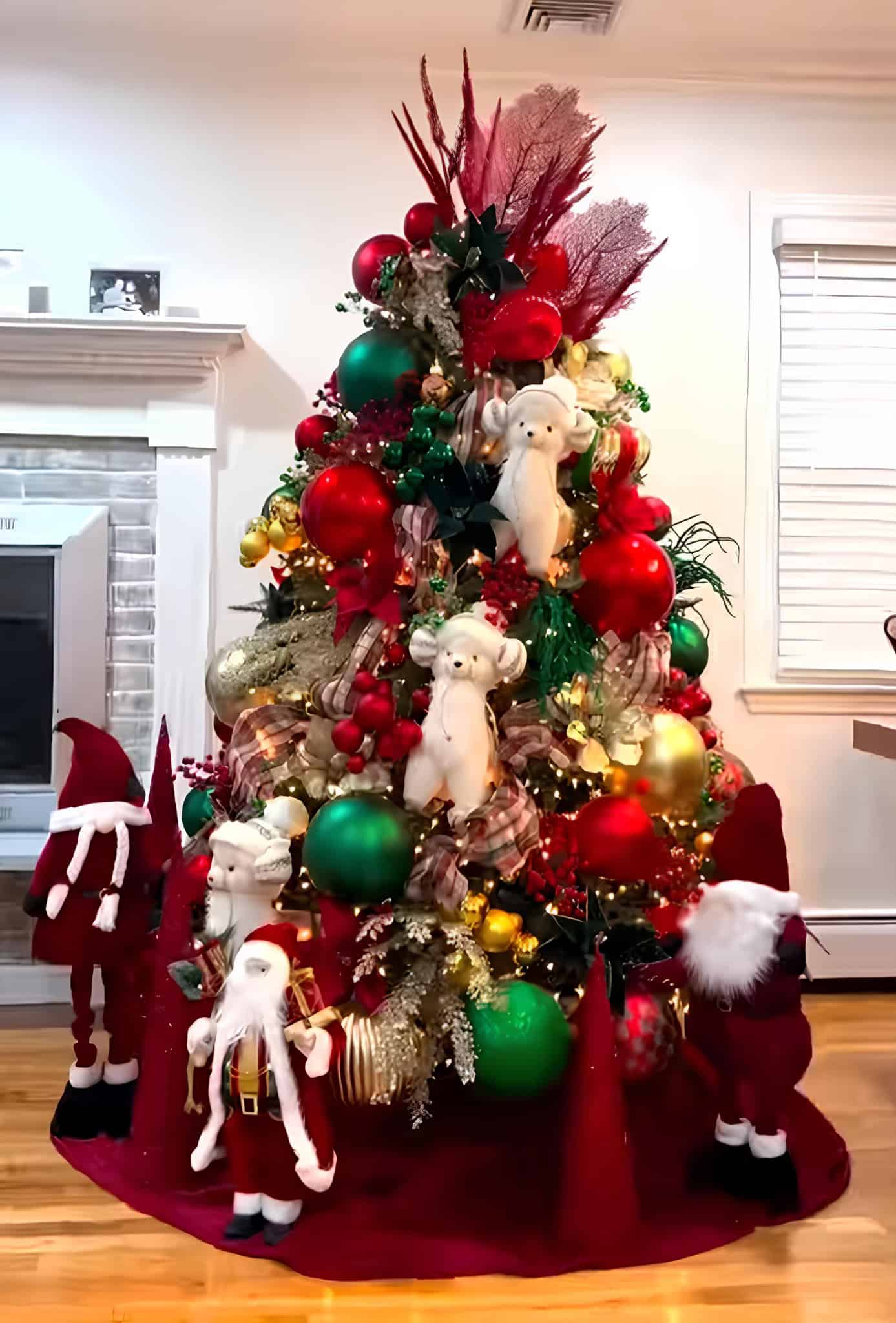 Traditional red, green, and gold Christmas tree with plush bears and Santas