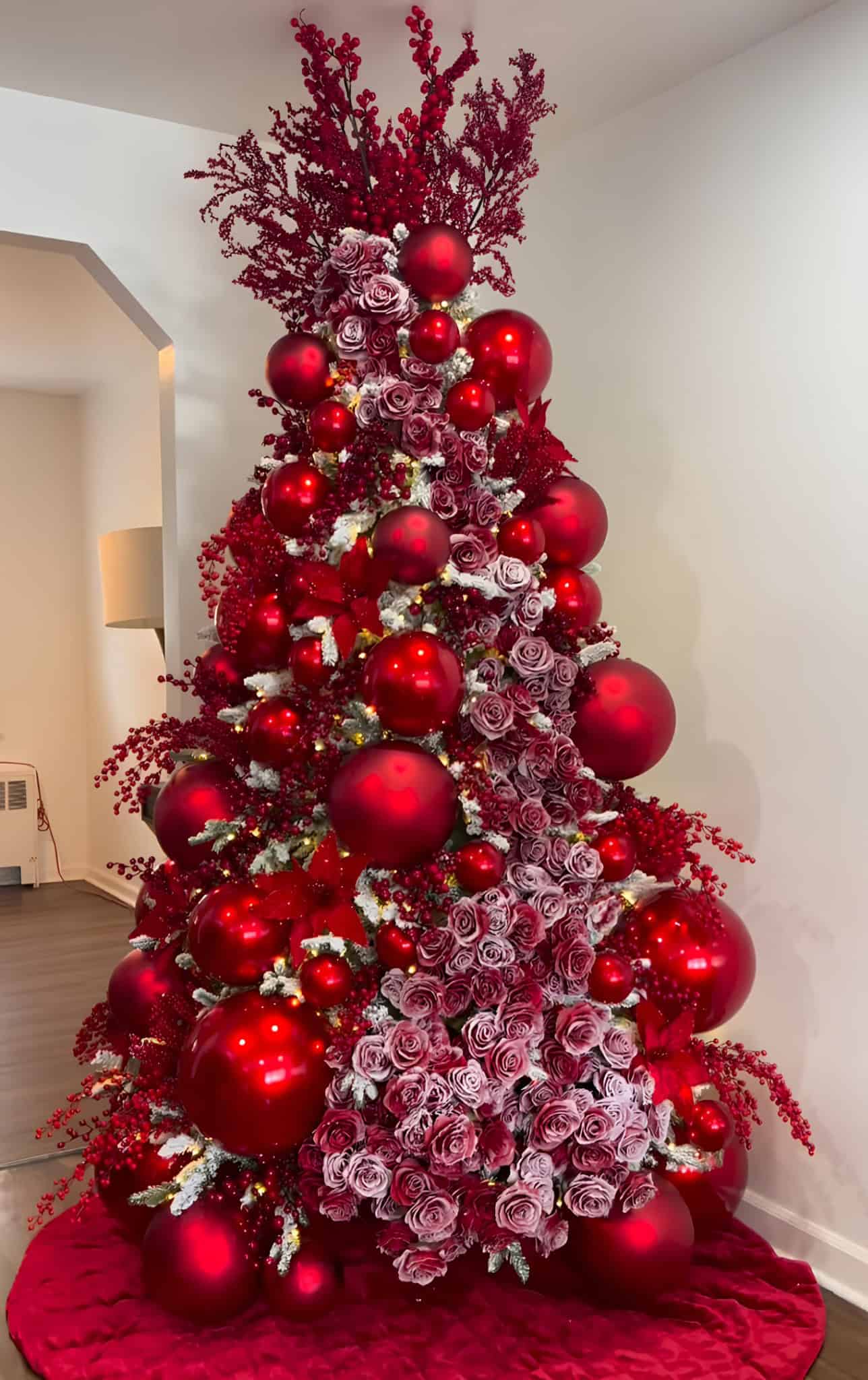 Opulent red Christmas tree packed with roses, berries, and matte ornaments