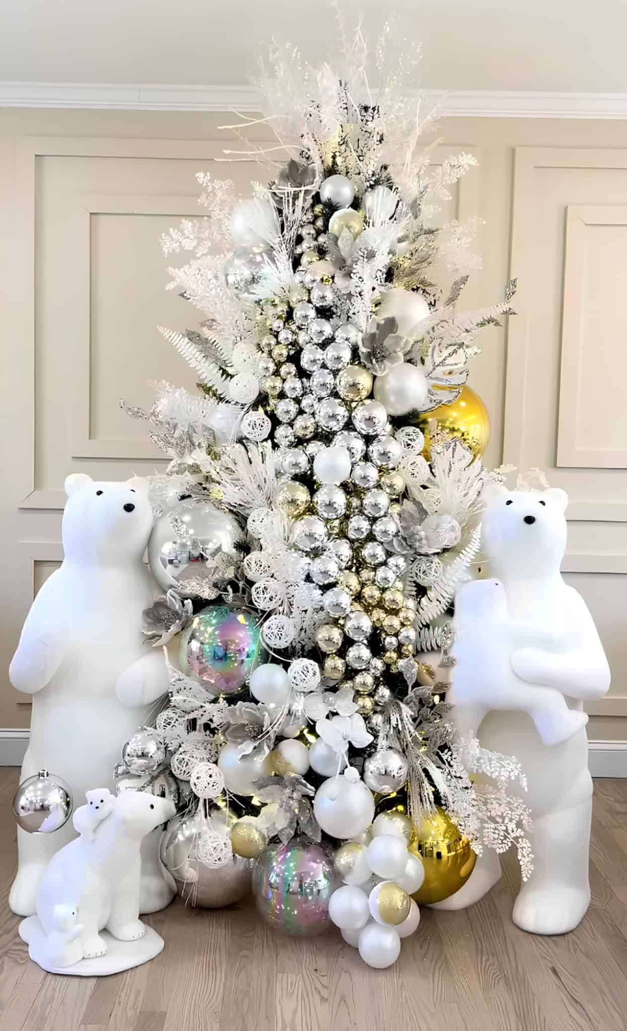 Silver and white winter Christmas tree with polar bear figures, iridescent ornaments, and frosted foliage