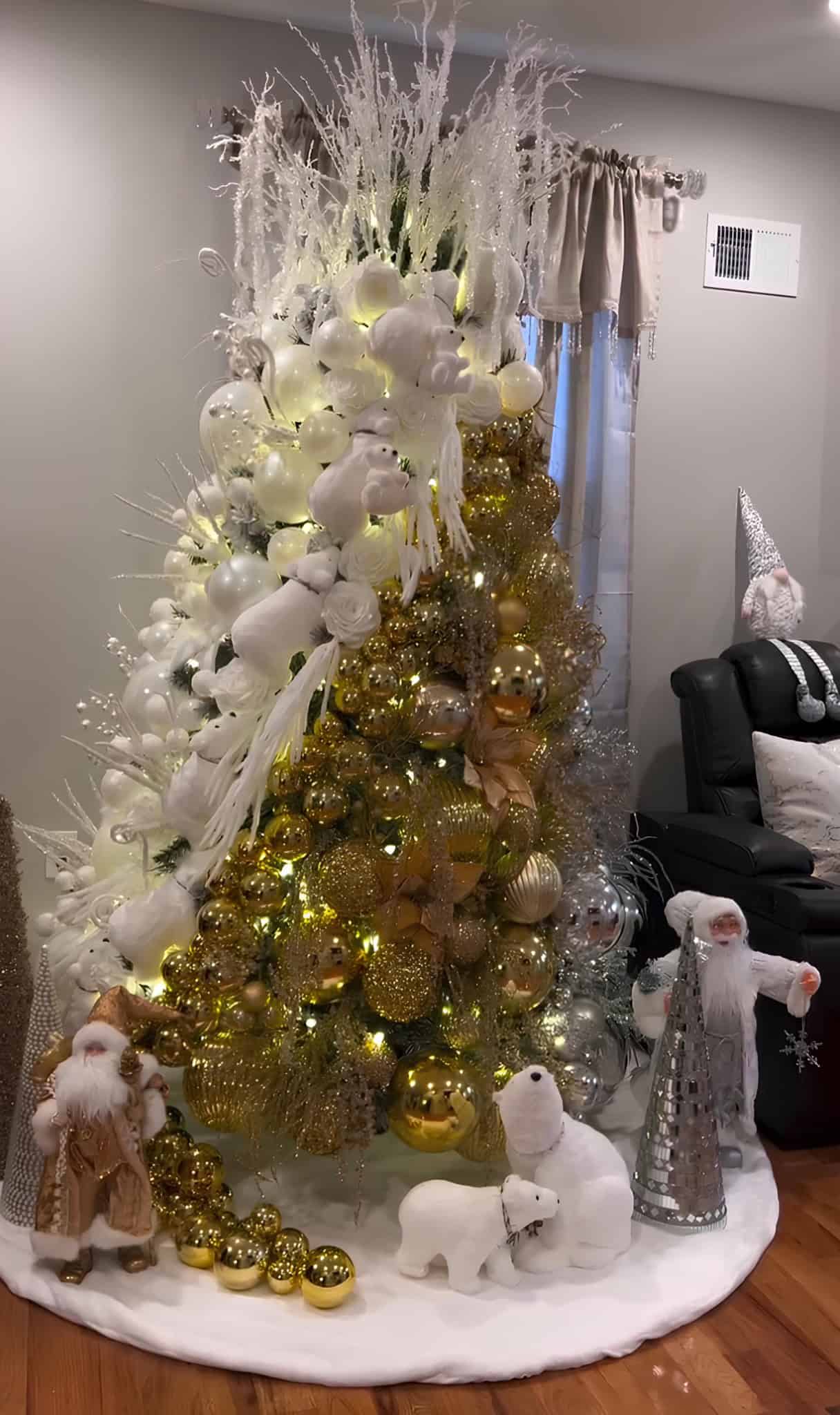 White and gold luxury Christmas tree with polar bear figures, glitter ornaments, and frosted branches
