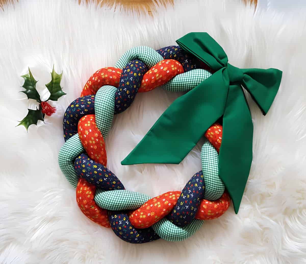 Braided Christmas wreath made of colorful fabrics with a large green bow