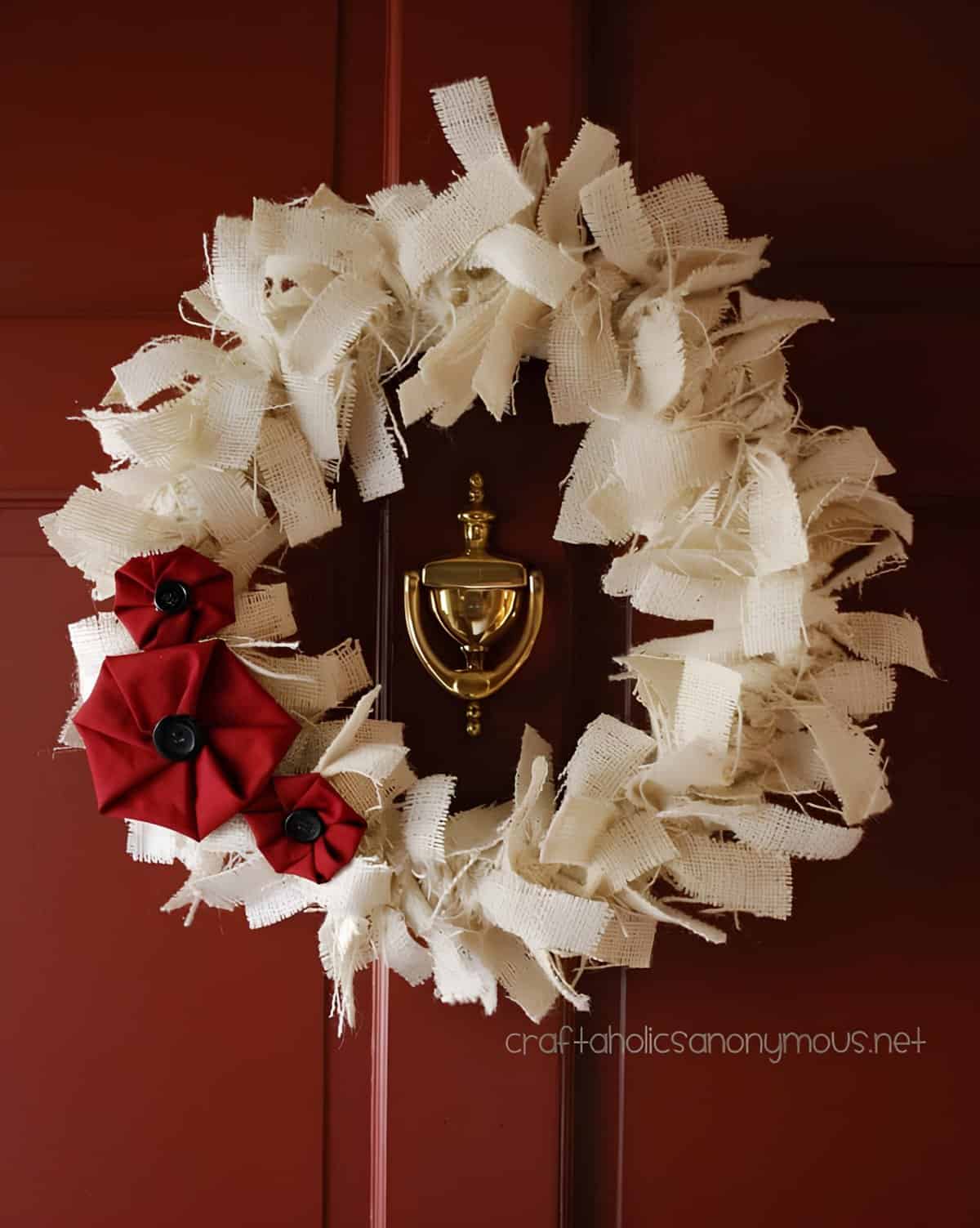 Burlap Christmas wreath with red fabric flowers and black buttons