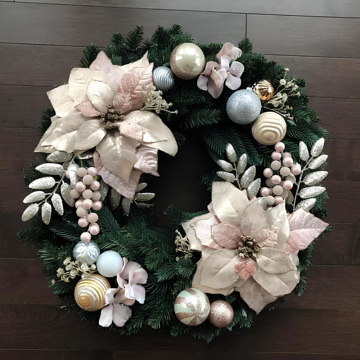 Elegant Christmas wreath with poinsettias, ornaments, and greenery