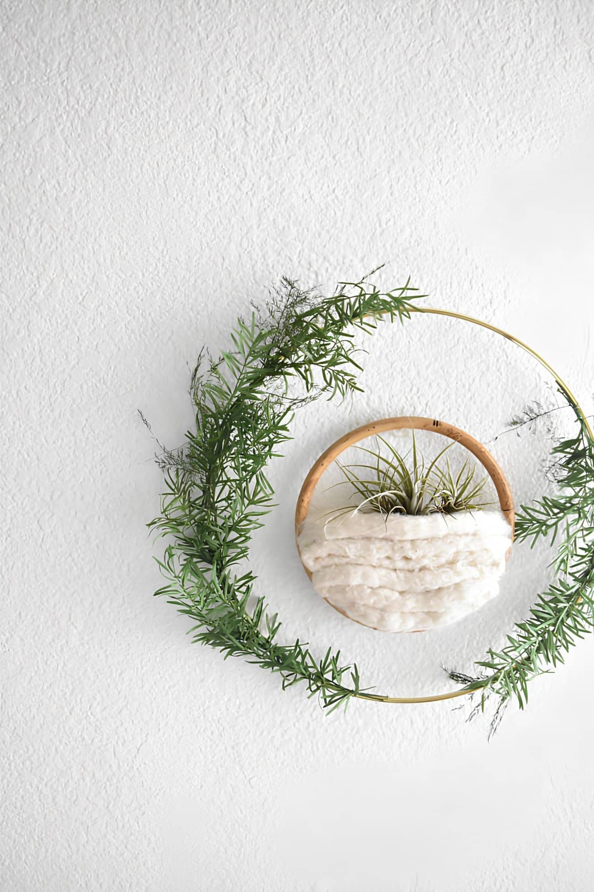 Minimalist Christmas wreath with greenery and a woven centerpiece
