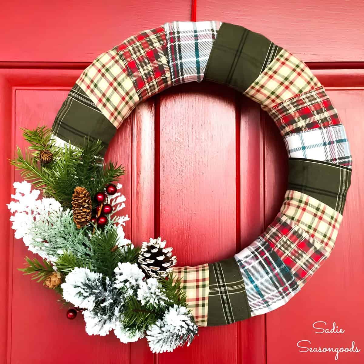 Patchwork plaid fabric wreath with greenery, snowy pinecones, and red berries