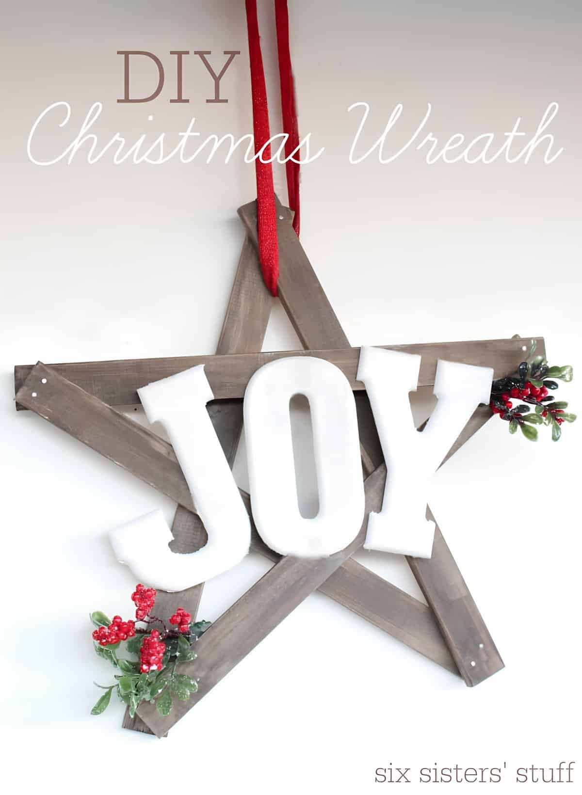 Wooden star Christmas wreath with large JOY letters and berry sprigs