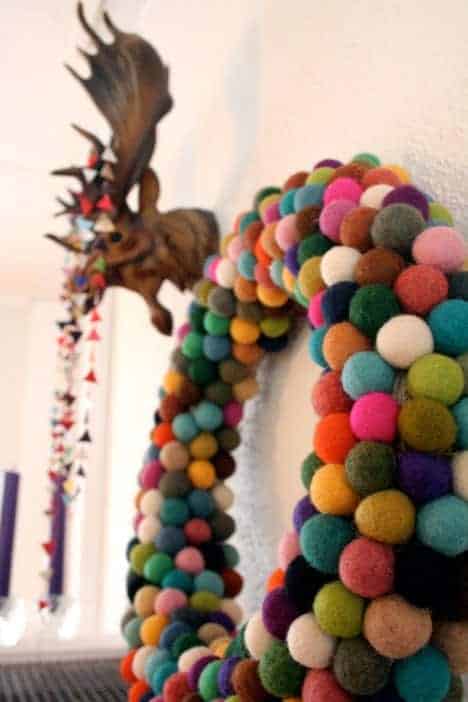 Vibrant multicolor pom pom Christmas wreath in close-up view