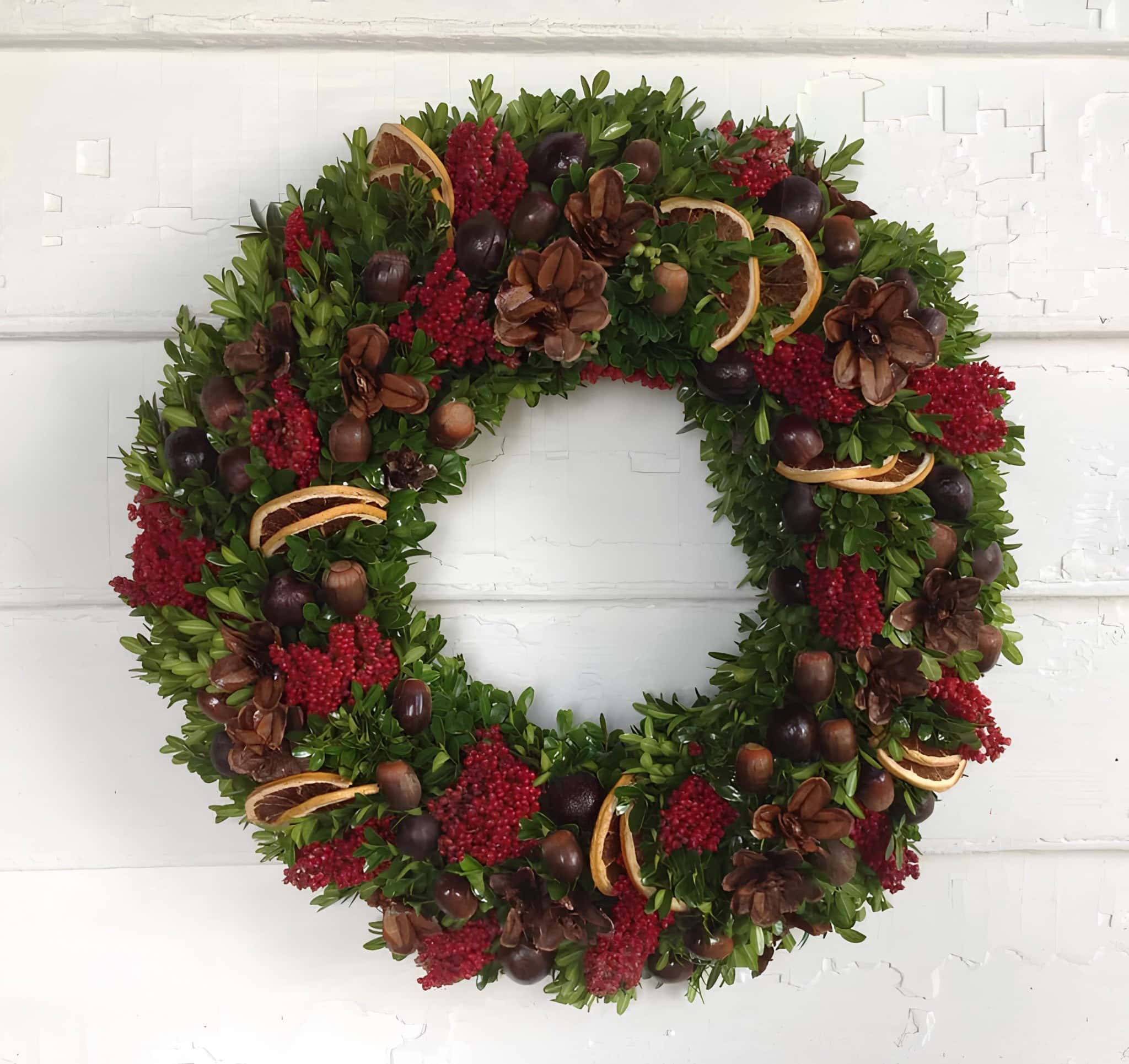 Natural Christmas wreath with dried orange slices, pinecones, red berries, and greenery