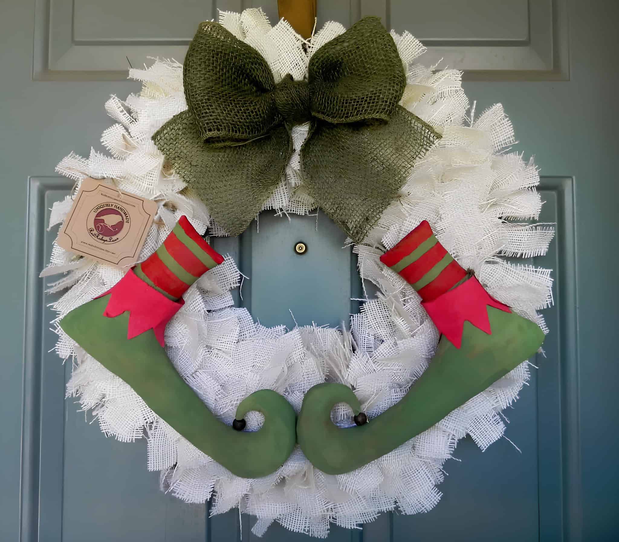 Whimsical Christmas wreath with elf legs and a burlap bow