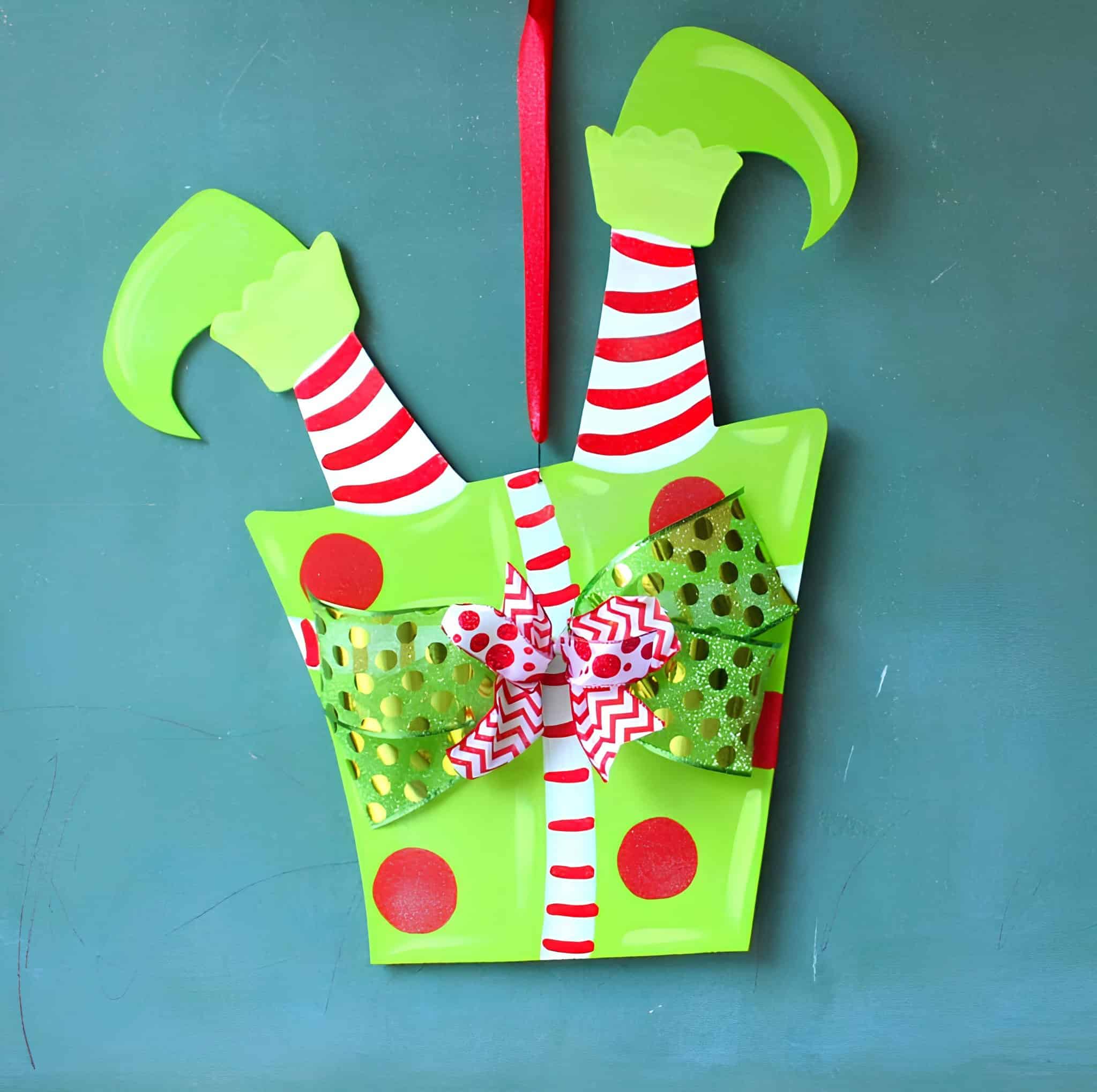 Bright green gift box door hanger with striped elf legs and festive bows