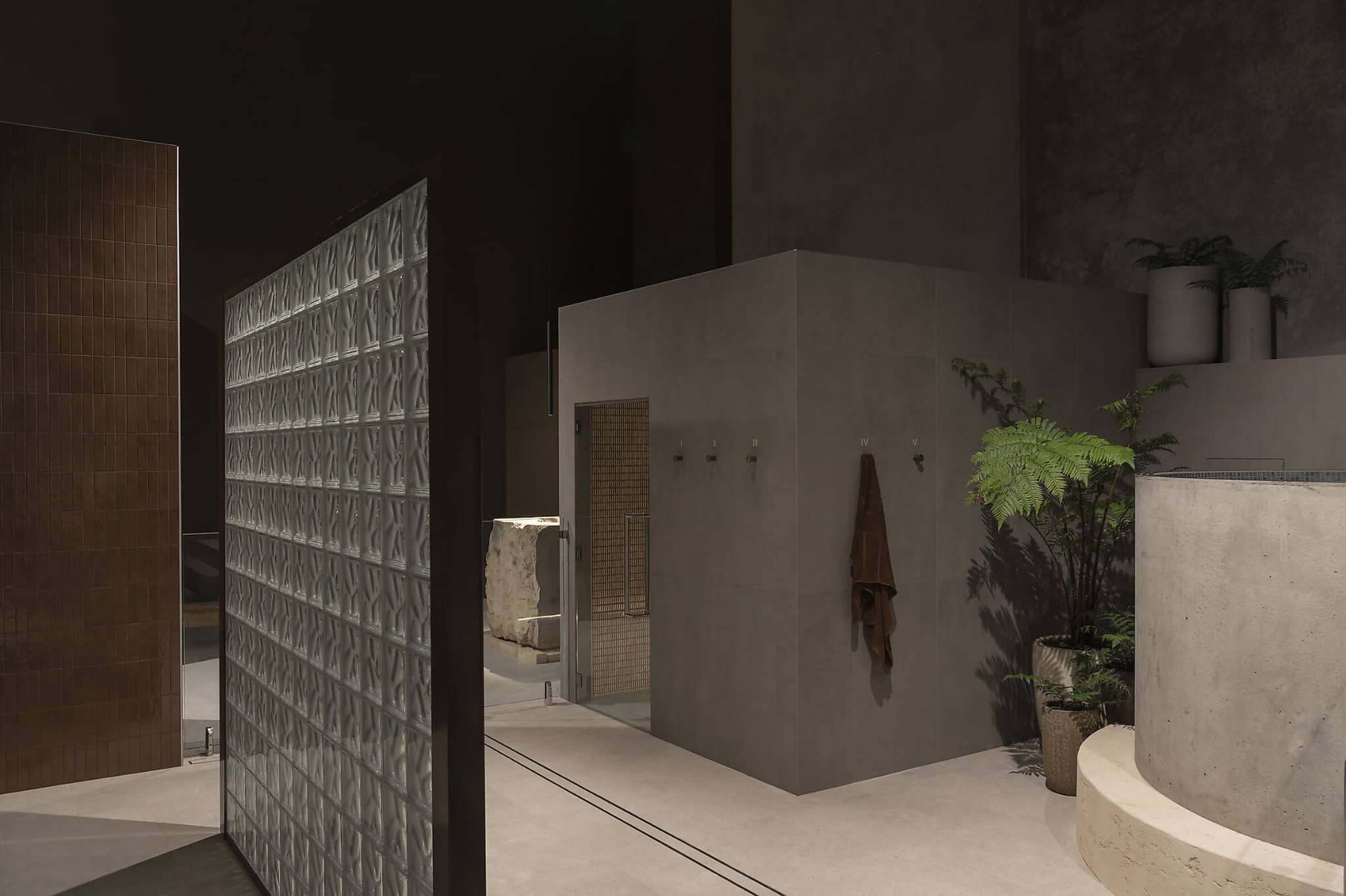 Modern minimalist bathroom interior with concrete walls and green potted plants, showcasing contemporary architecture and interior design elements.
