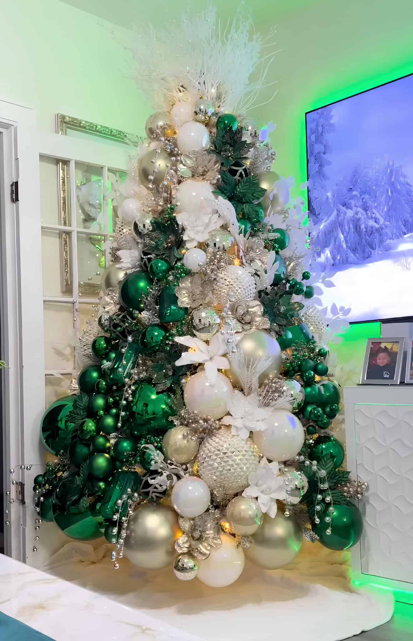 Emerald green, gold, and white Christmas tree with luxurious ornaments and floral details