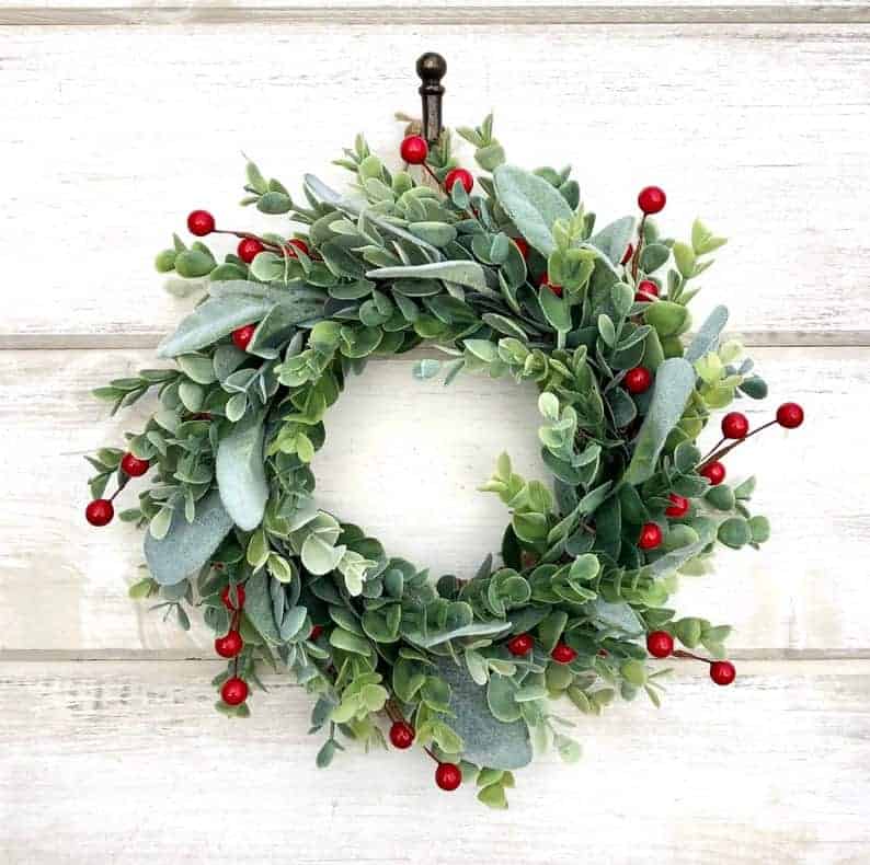 Eucalyptus Christmas wreath with red berries on white wall
