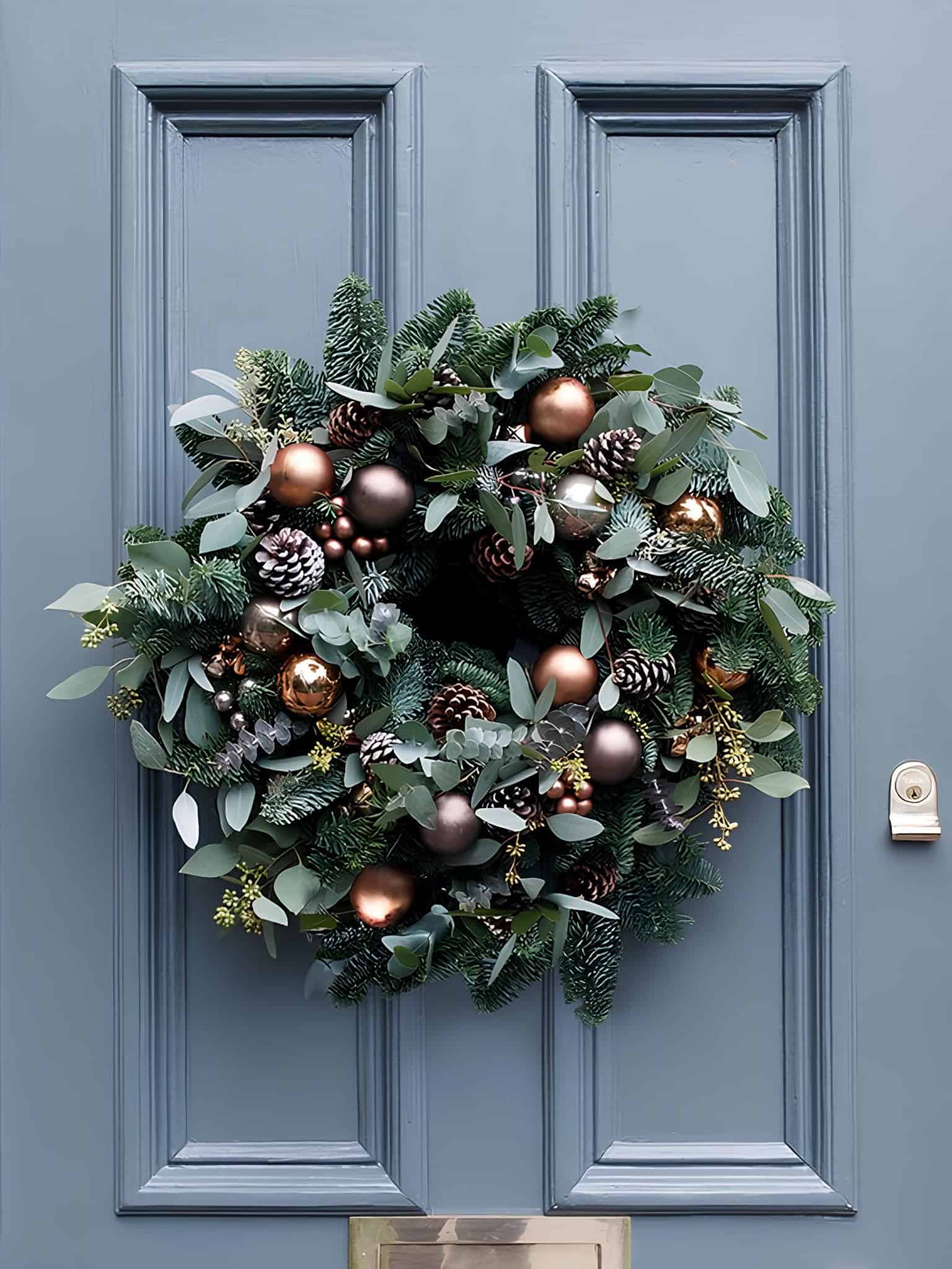 Evergreen Christmas lantern wreath with pinecones and metallic ornaments