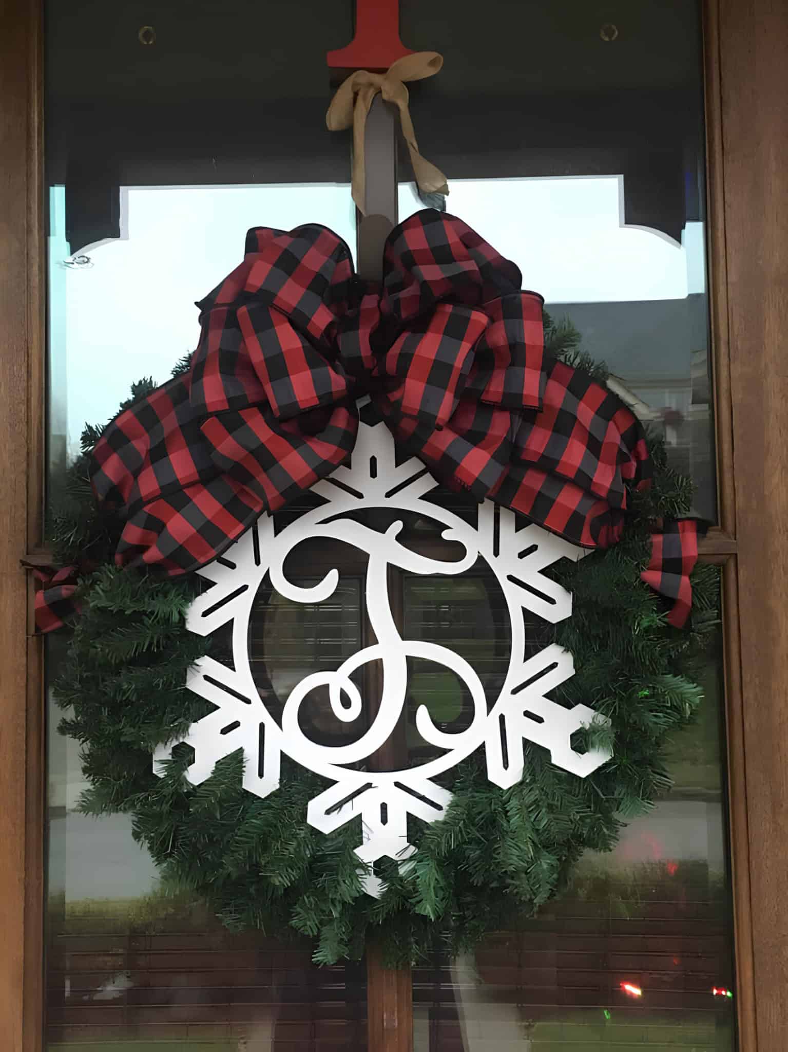 Classic evergreen wreath with white monogram snowflake and buffalo plaid bow