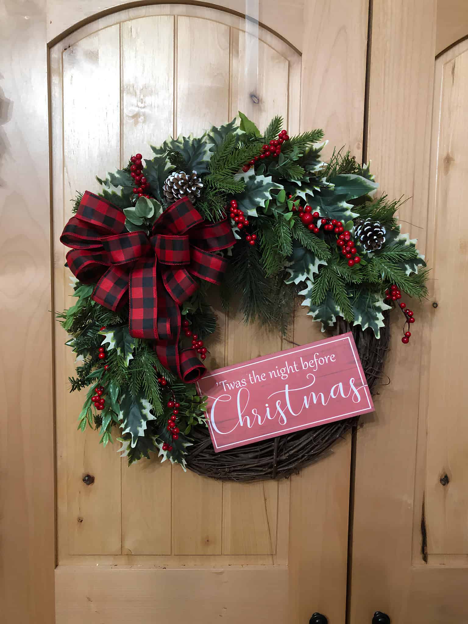 Grapevine Christmas wreath with plaid bow, holly and a small Christmas sign